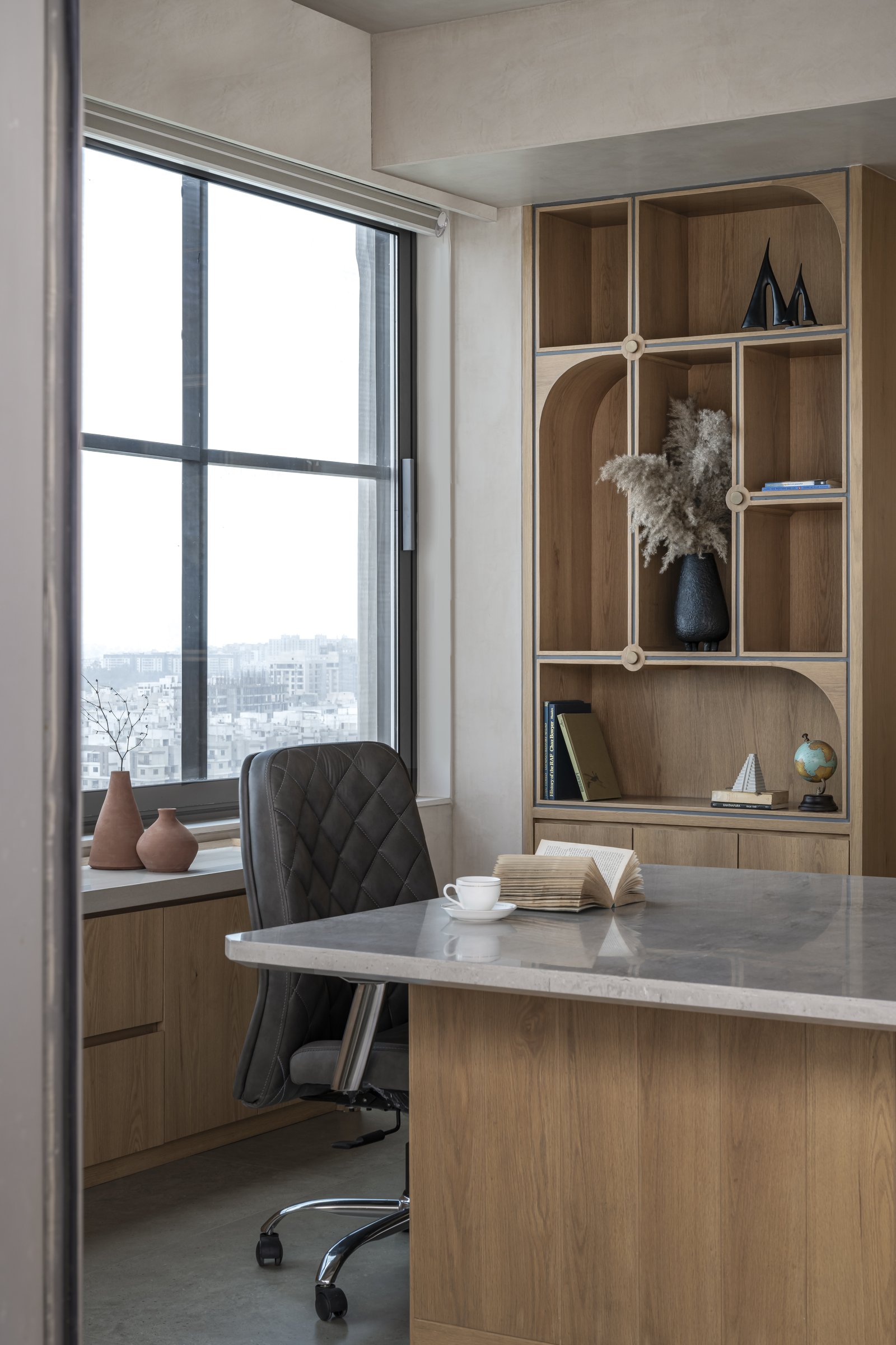The private study corner, where an arched display unit sits beside the window