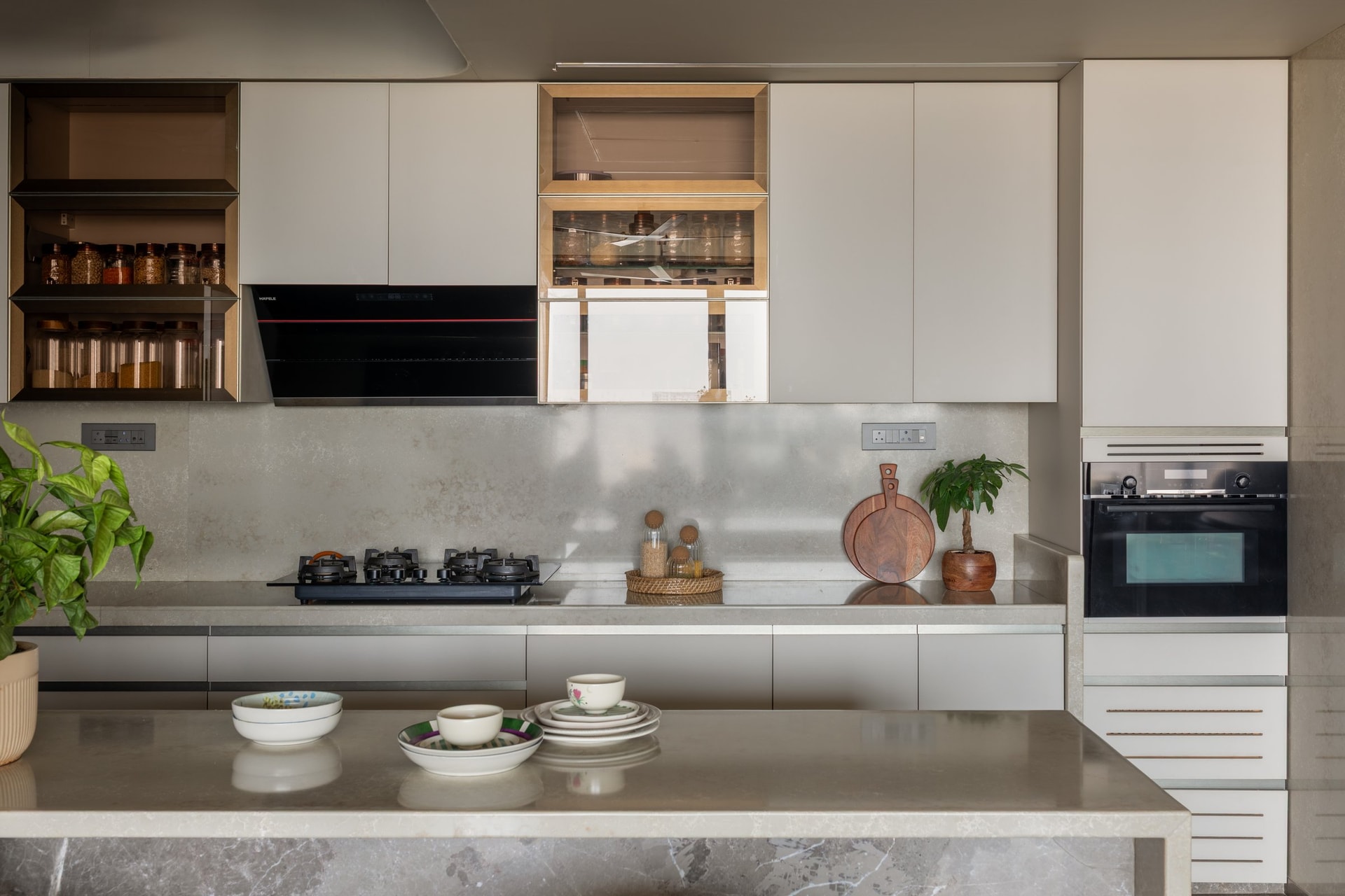 The kitchen, where light cabinetry and a continuous stone-look counter keep the working surfaces visually quiet