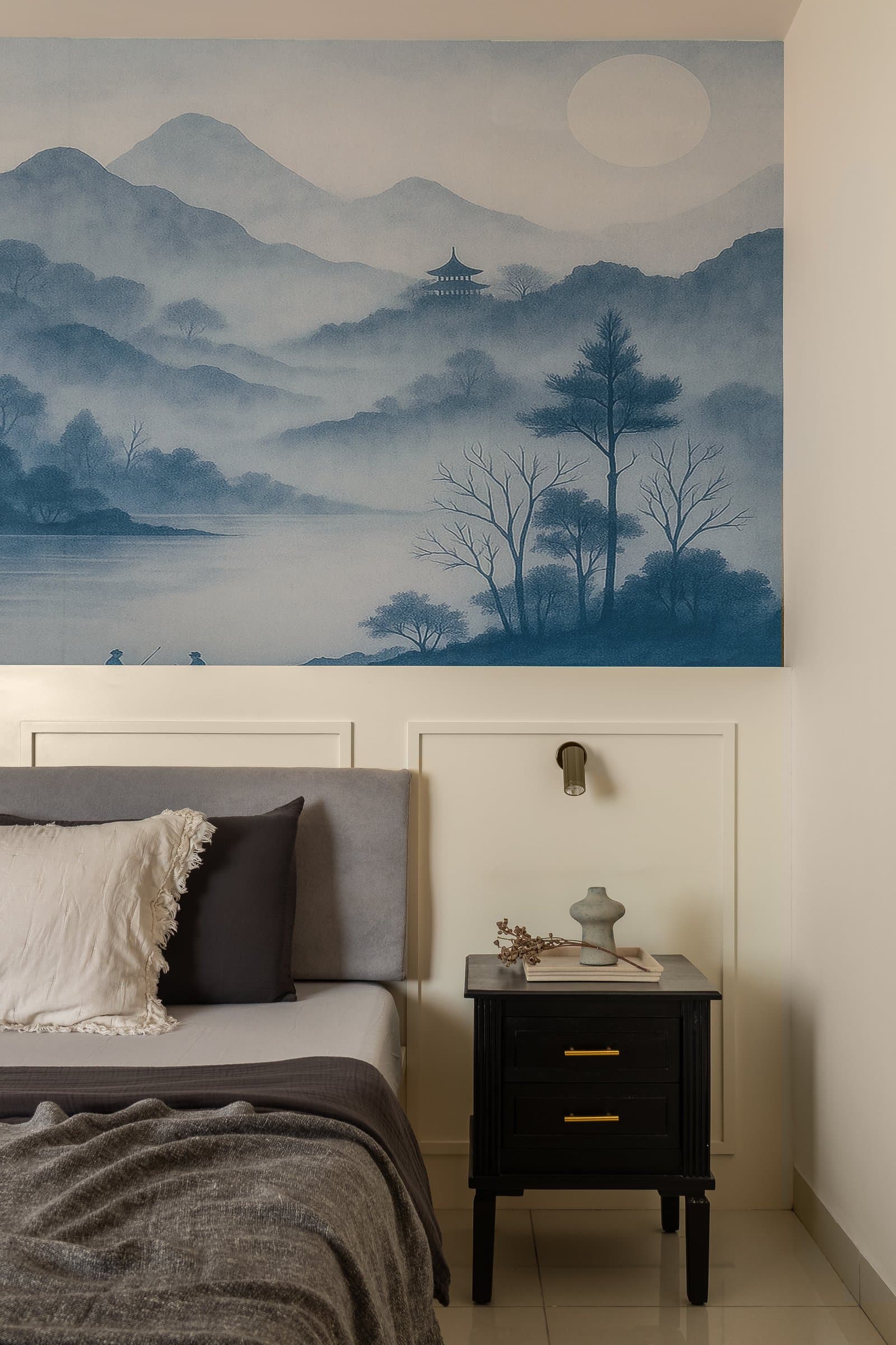In the master bedroom, an ink-wash mural of misty mountains above a panelled headboard wall sets a contemplative tone distinct from the living spaces