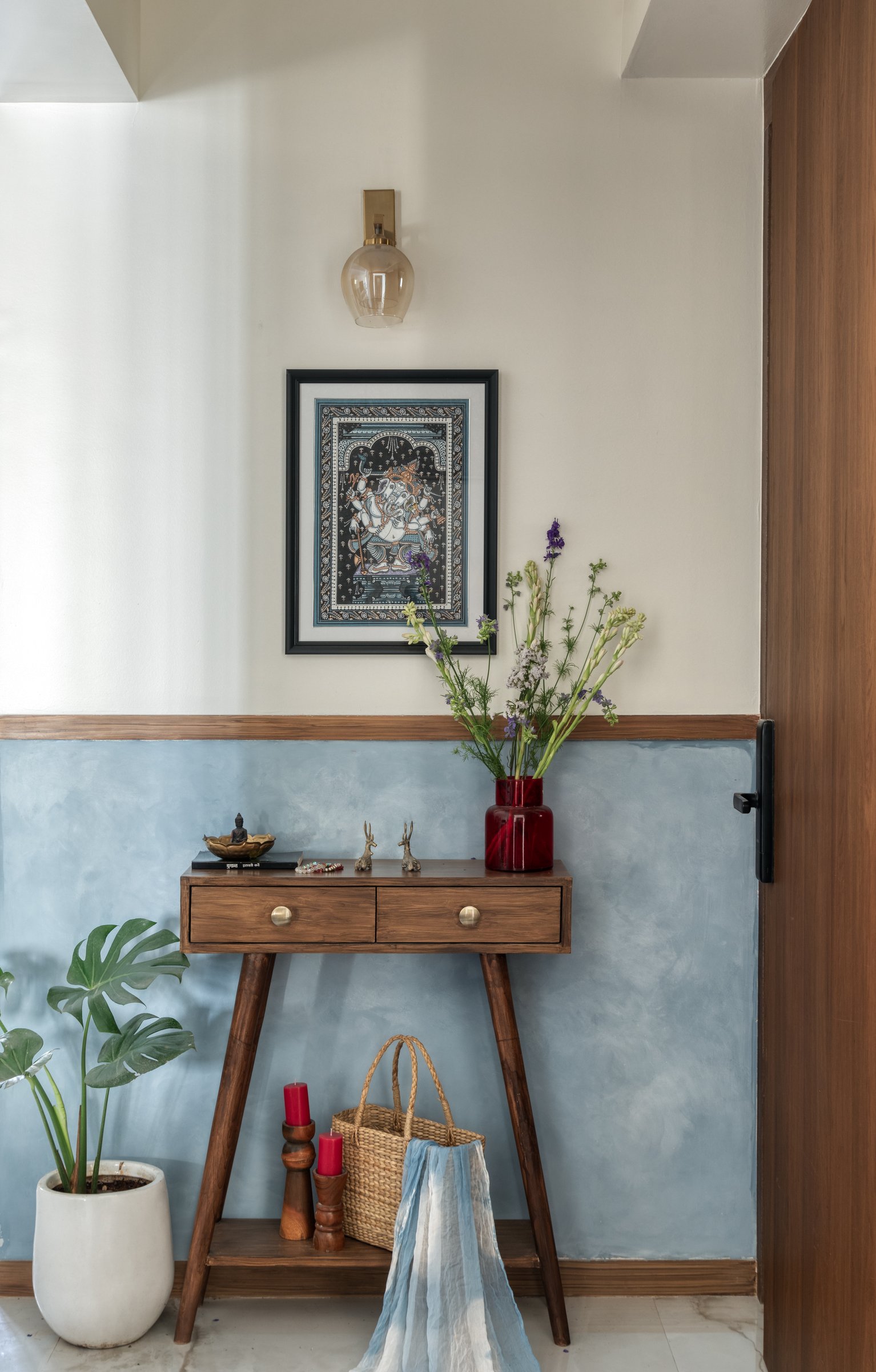 The entry vignette, where blue limewash and a timber console establish the home's material vocabulary from the threshold