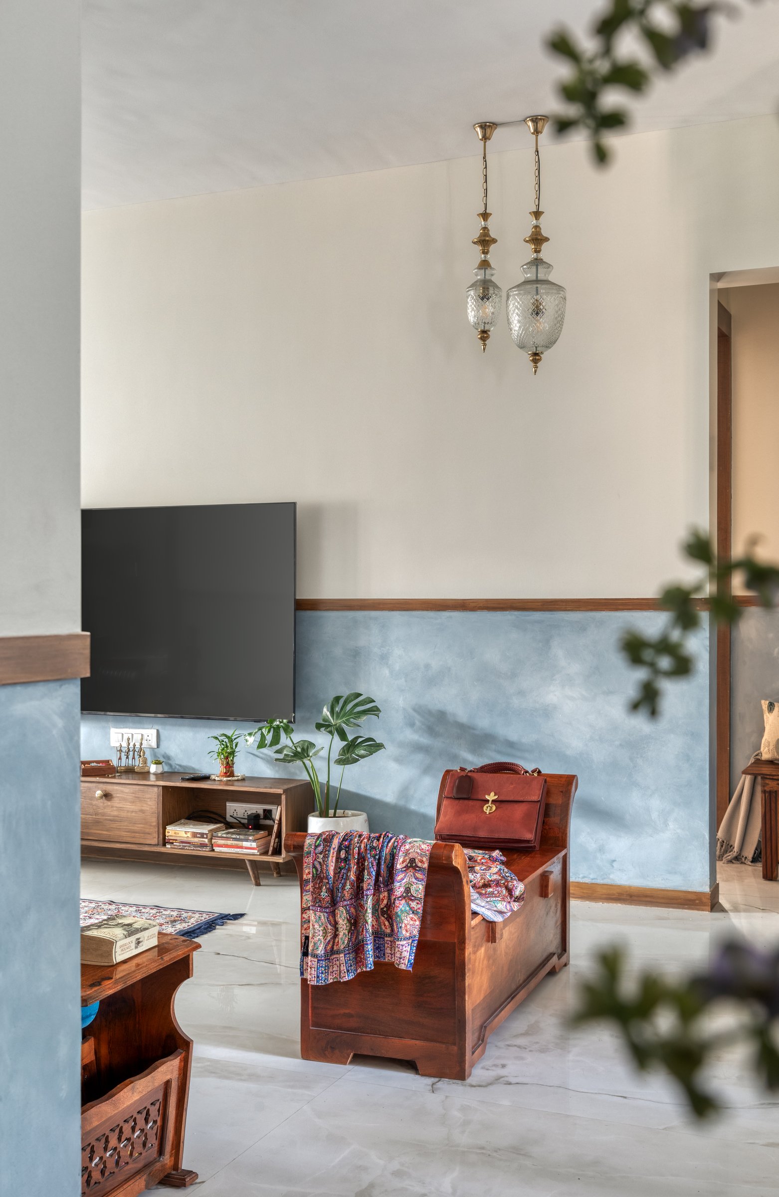 The media wall and storage bench, where cut-glass lanterns create a gentle echo of the foyer beyond
