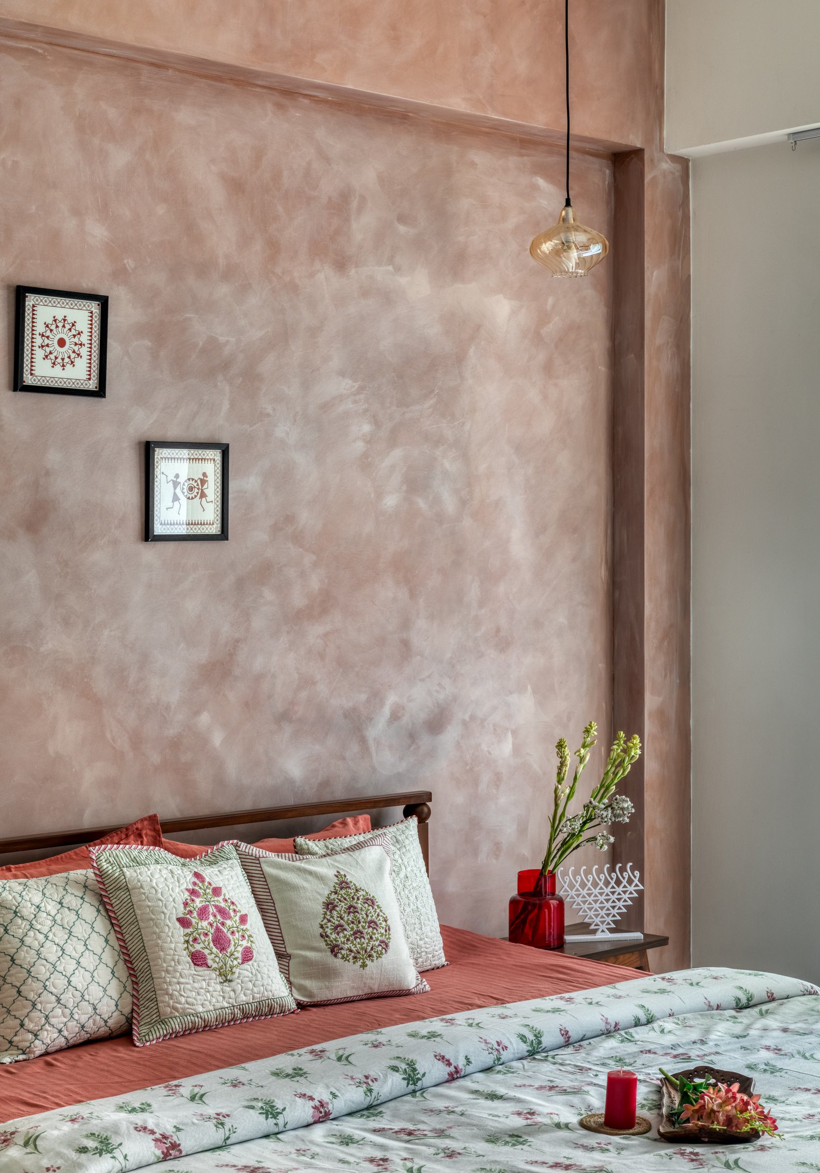 Rose-toned limewash at the headboard, its tonal variation a deliberate contrast to the Warli-style prints it holds