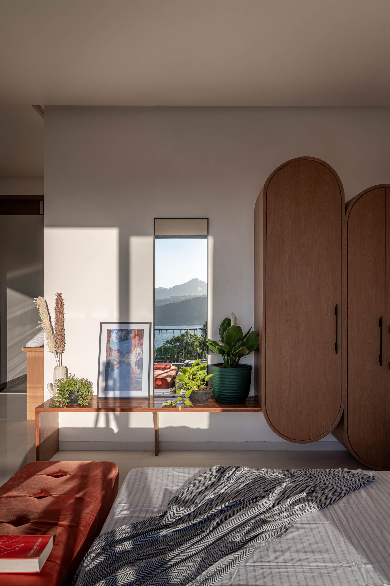 A vertical window in the master bedroom frames the distant fort like a painting