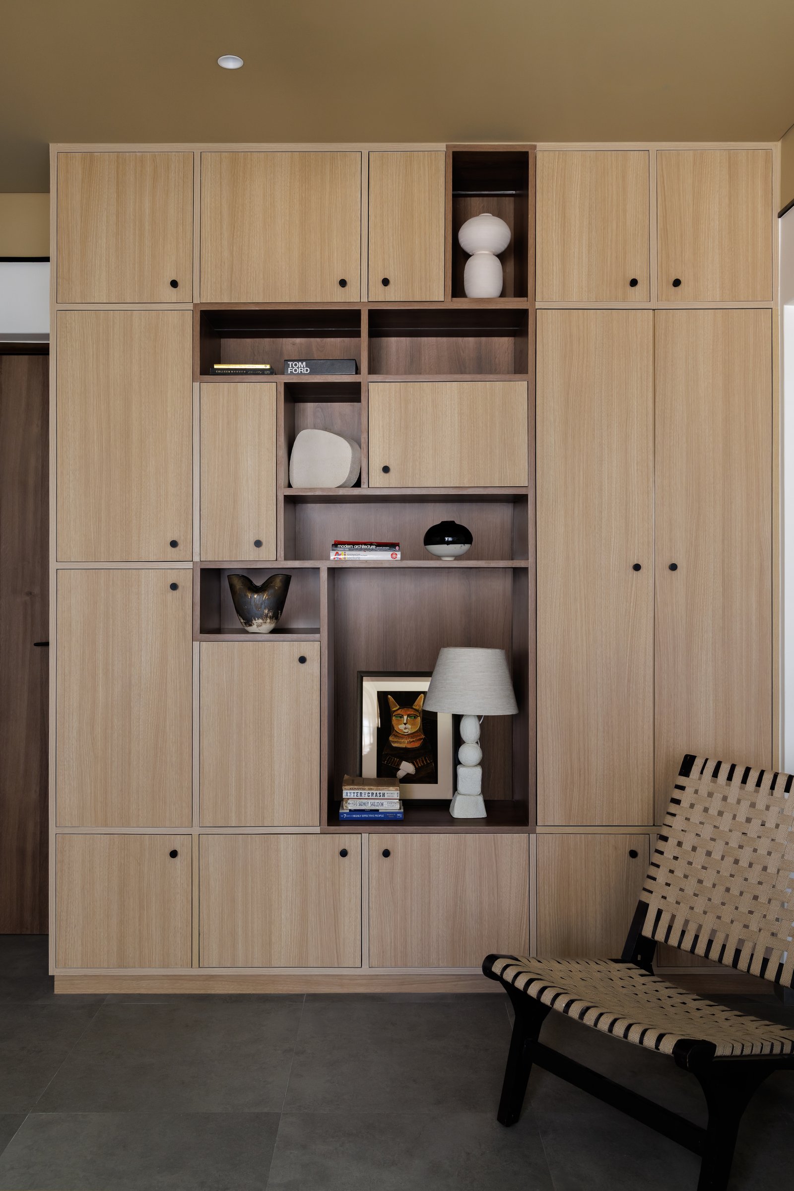 The display wall: a pale oak grid that reads as a curated library of how the family lives