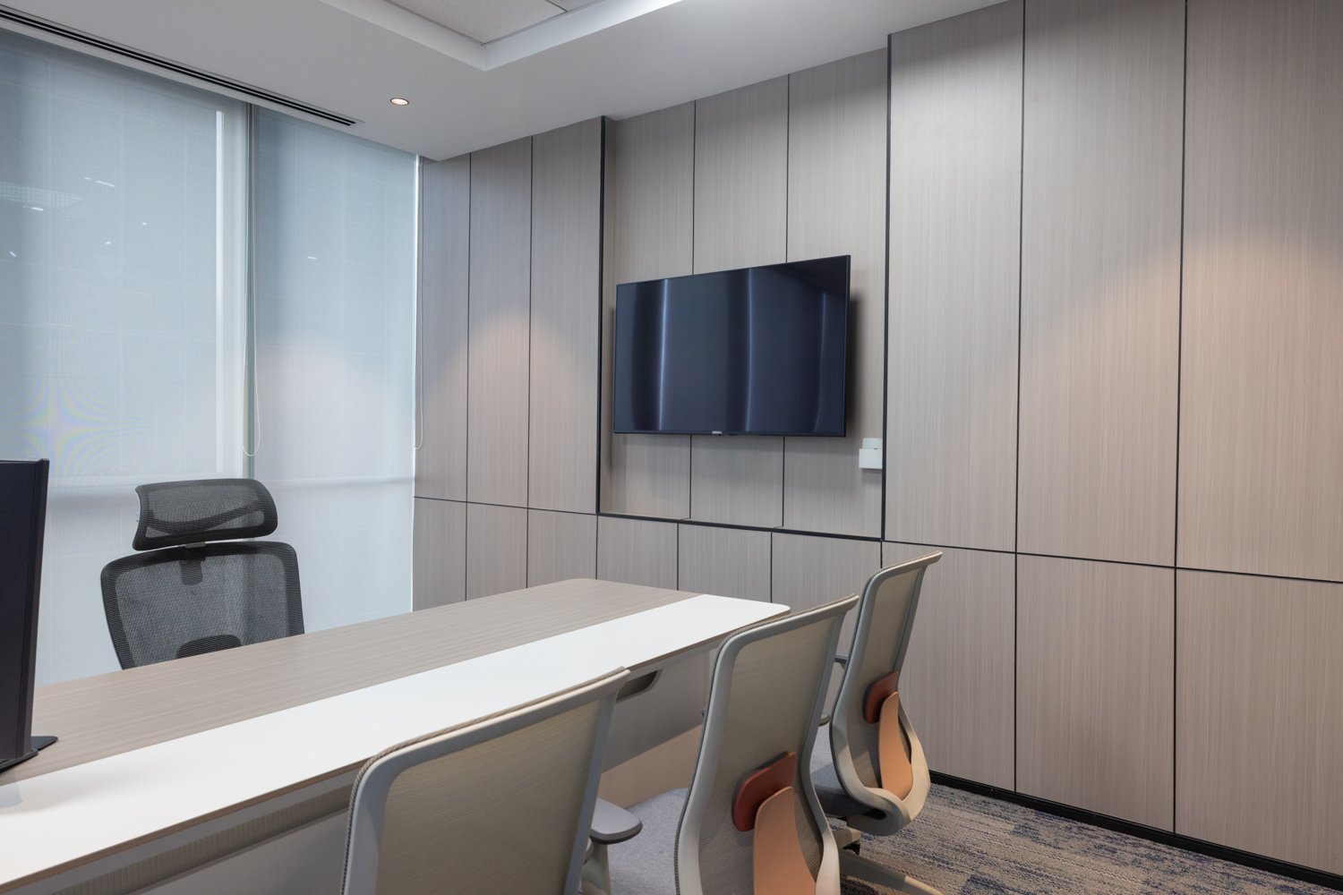 The private cabin: a full wall of wood-grain panelling, divided by slim recessed reveals, allows the room to recede