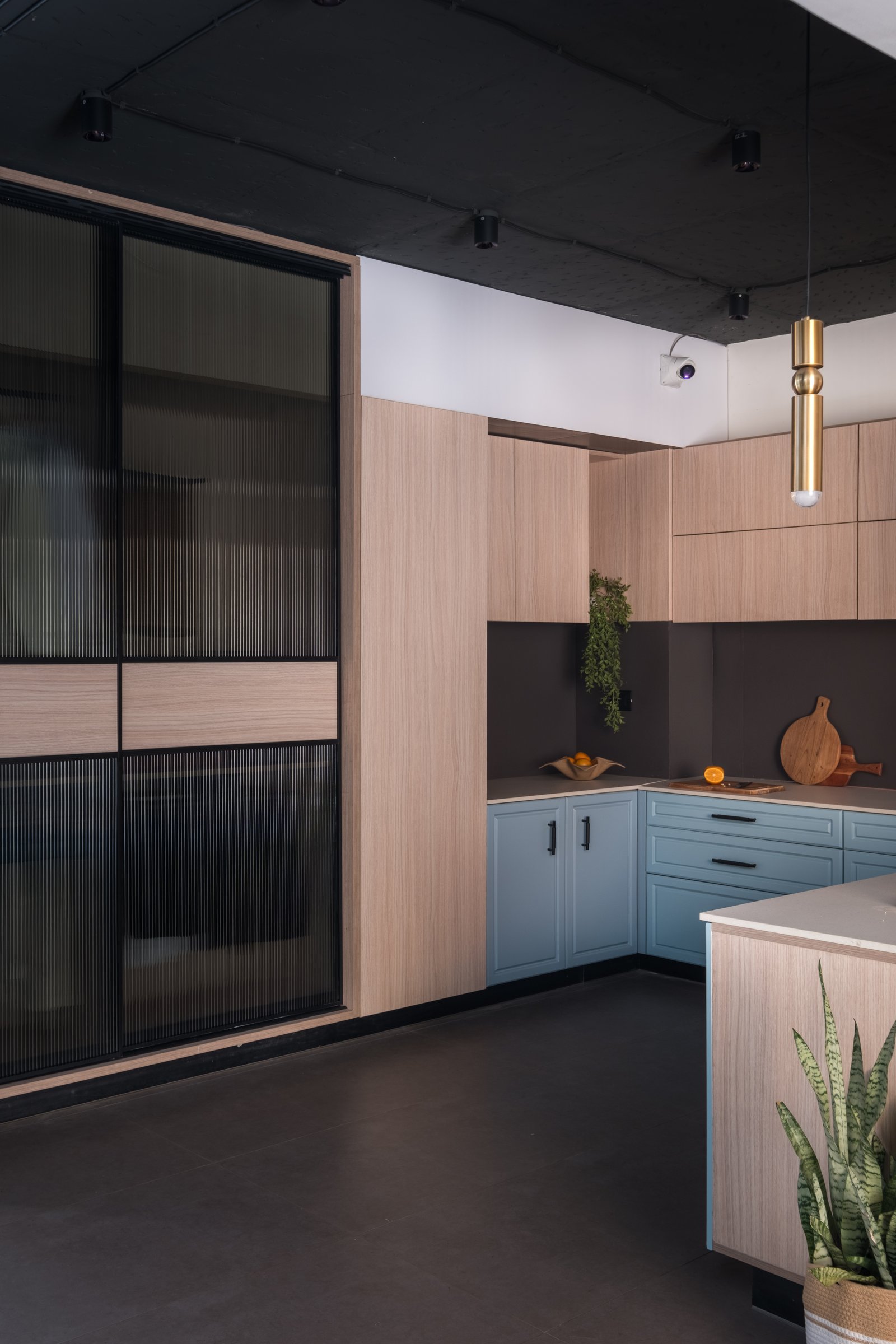 A modular kitchen vignette in pale blue and oak, the one corner where colour is allowed to lead