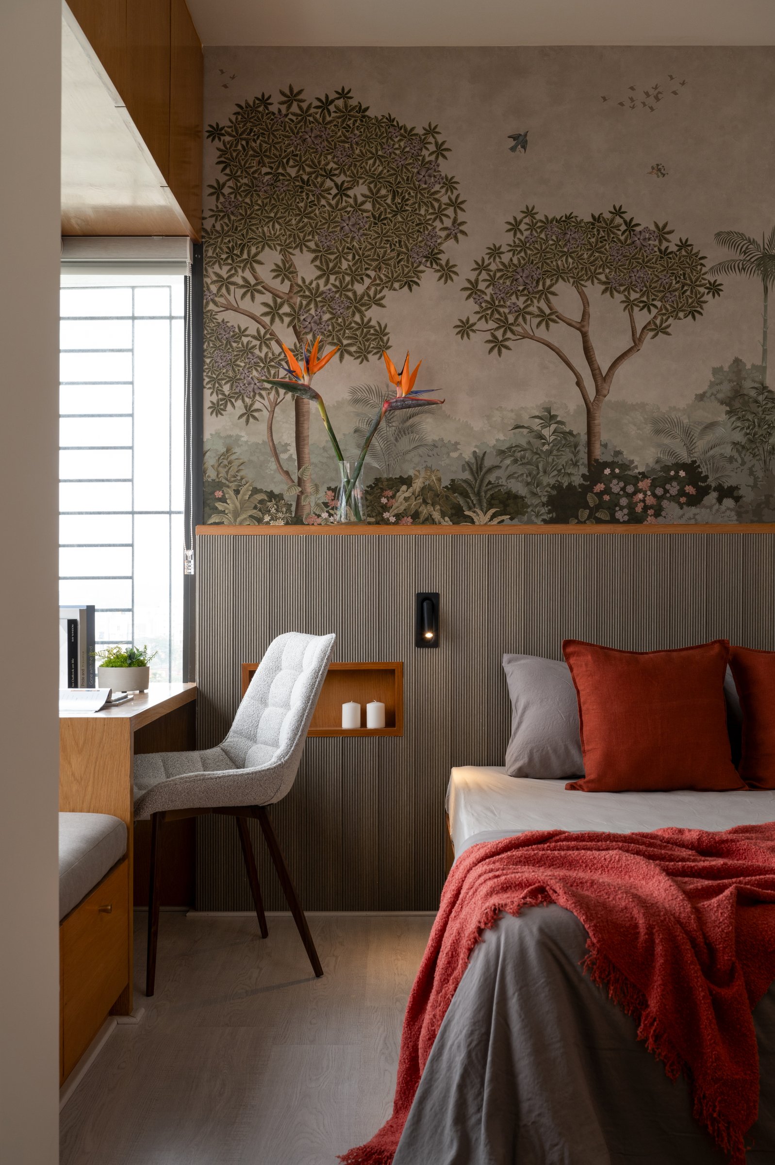 A closer view of the headboard wall, where reeded wood absorbs sound and folds storage and a candle niche into a single continuous surface
