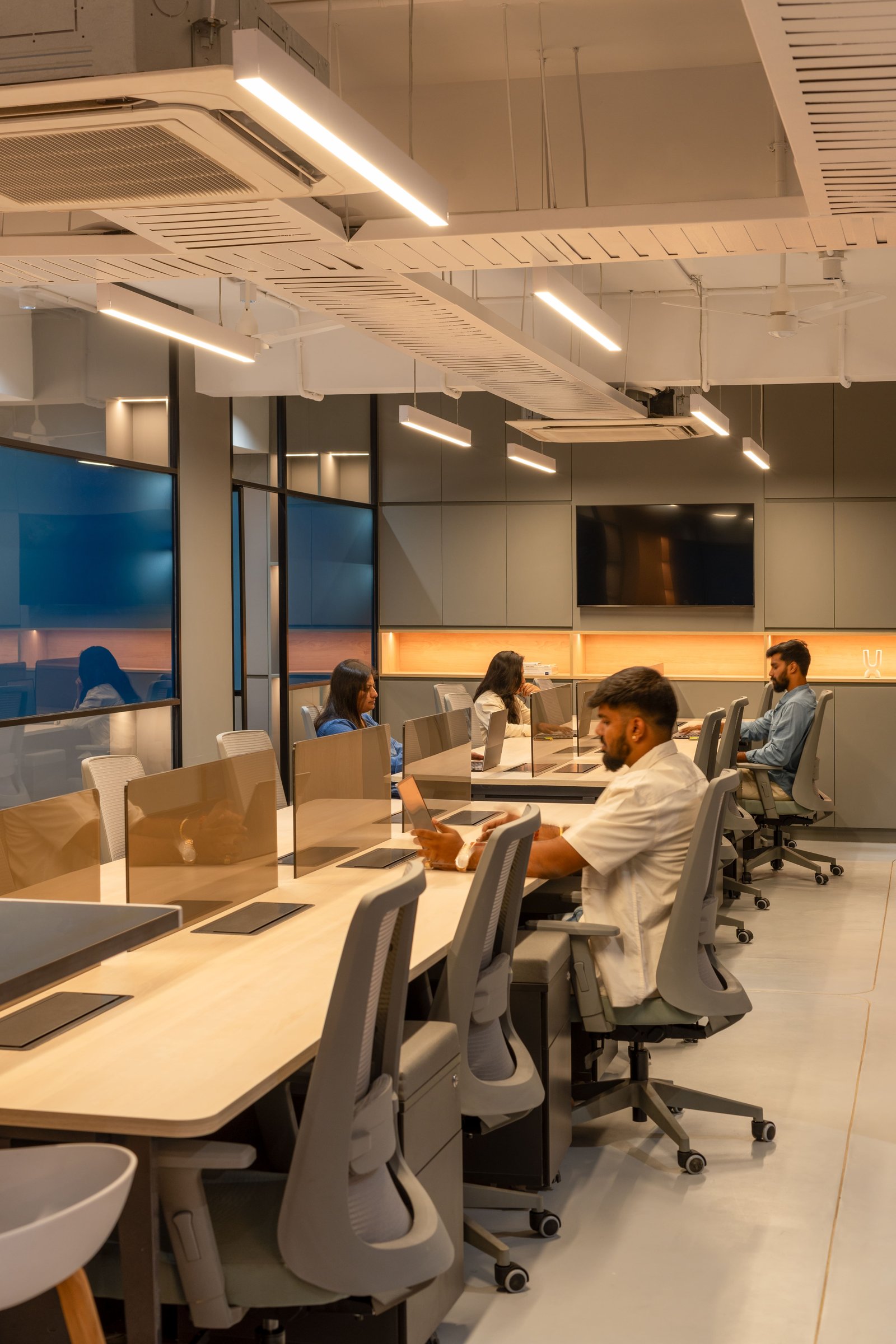The open workstations, where exposed services overhead are left honest against the disciplined surfaces below