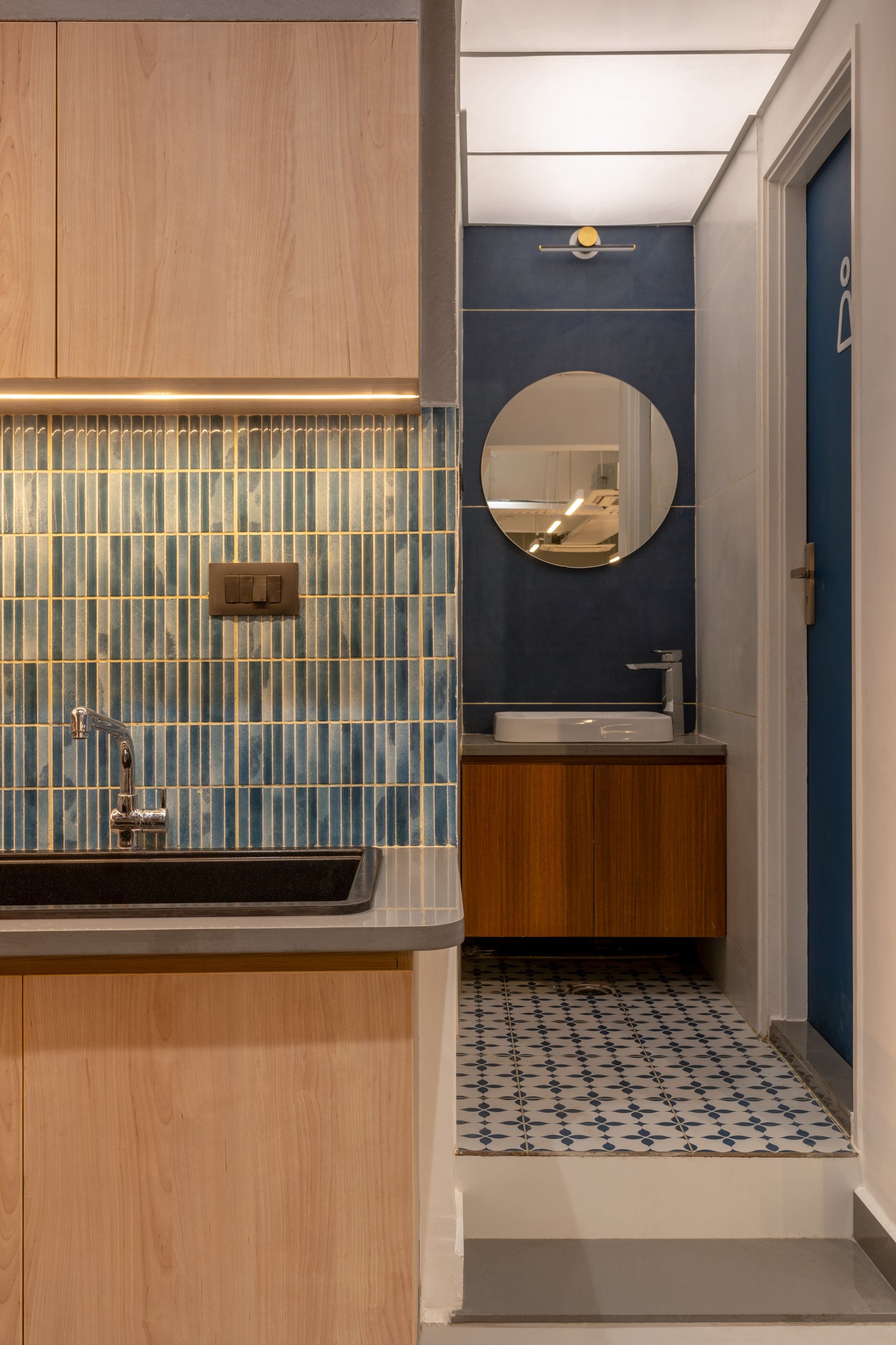 The washroom service area, where the hand-glazed tile reappears alongside a patterned encaustic floor