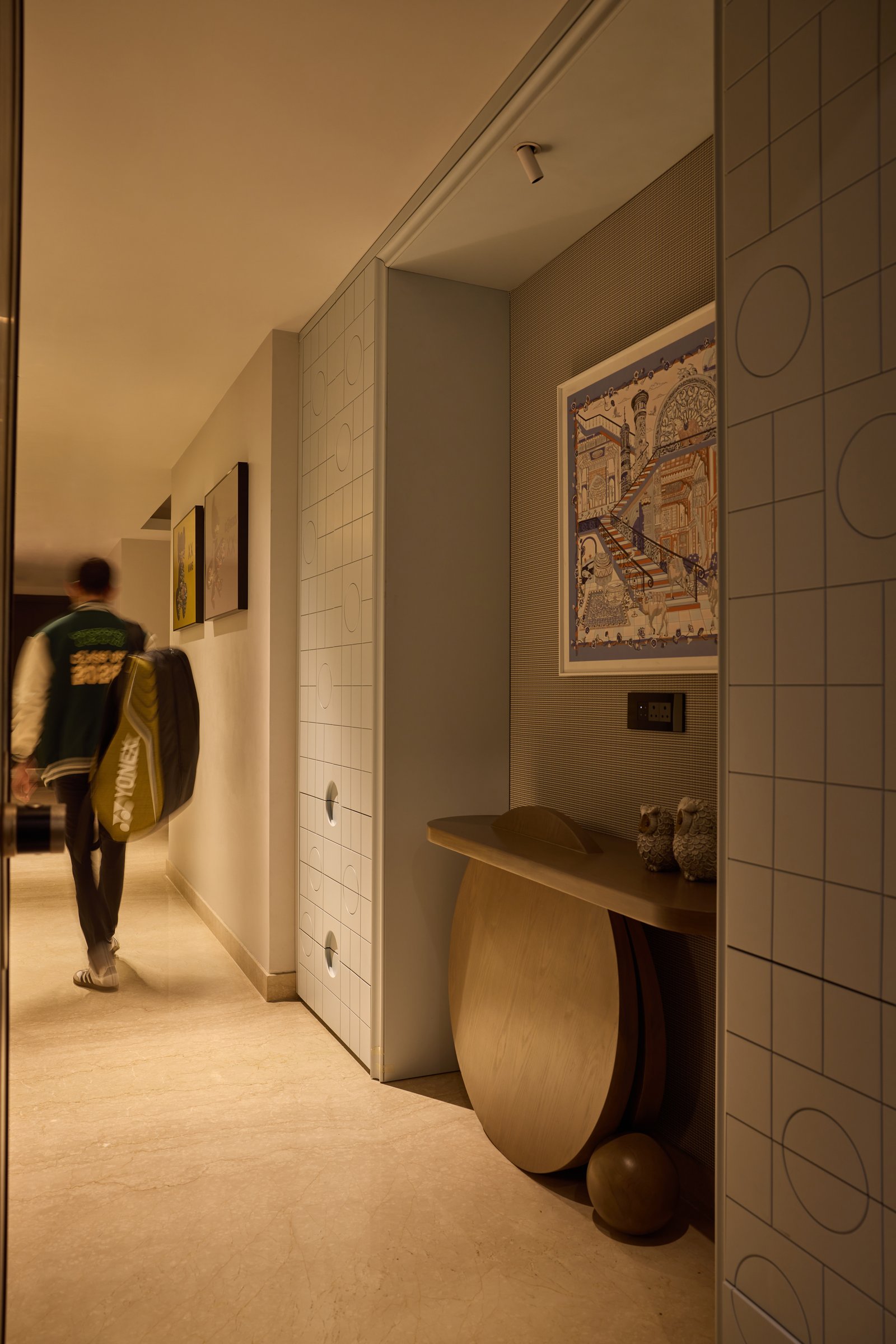 The entry: a curved wooden console and grid-patterned screen wall set a quietly composed tone before the home opens up