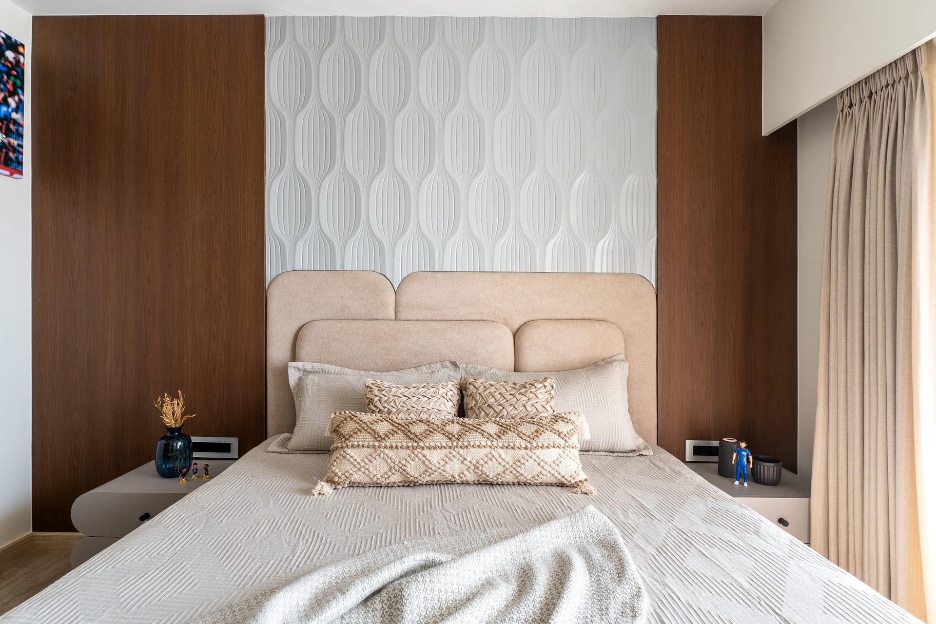 A straight-on view reveals the room's quiet symmetry, twin curved headboards mirrored by matching pebble-form bedside tables