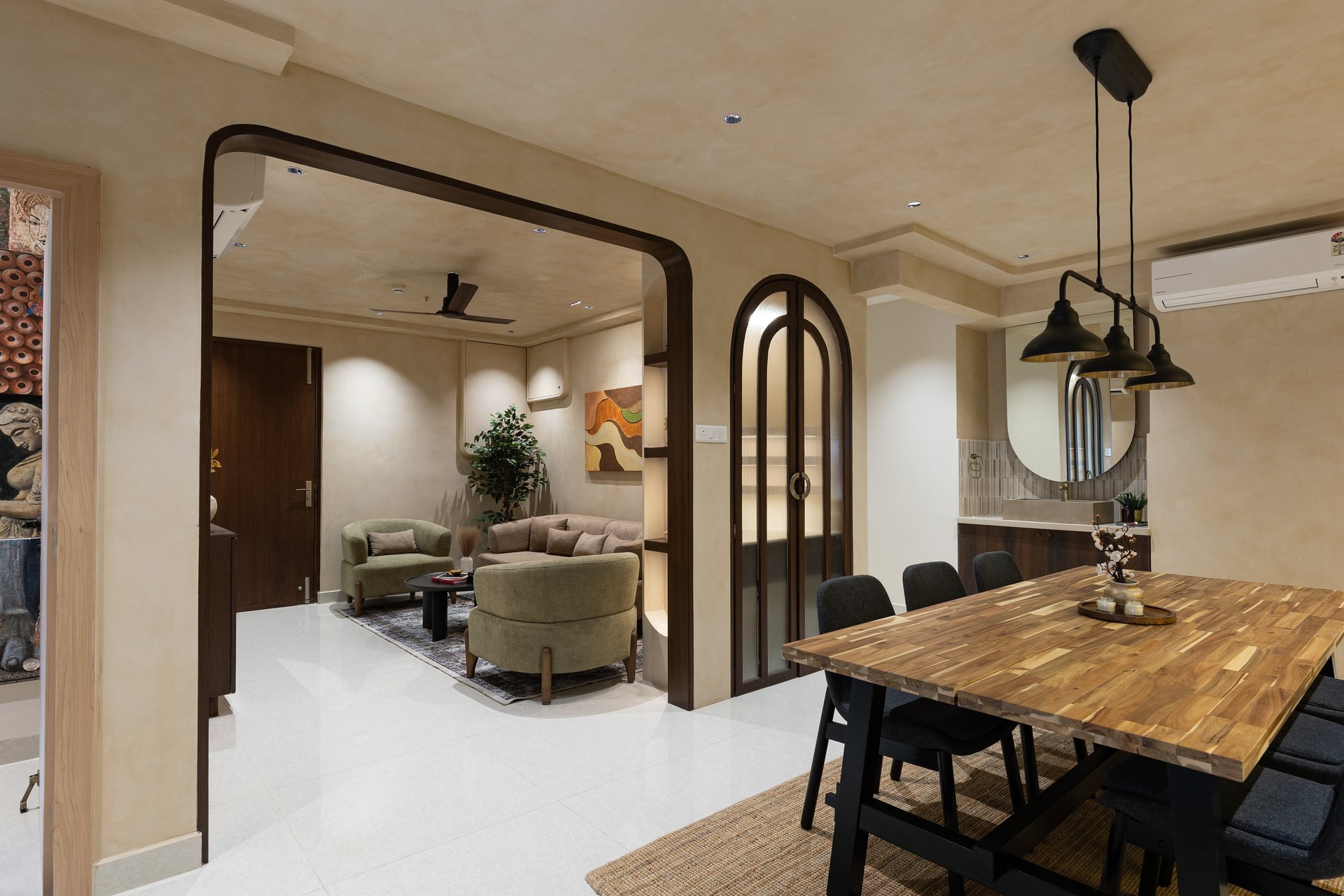 The bespoke puja cabinet with fluted-glass arched doors, holding the threshold between drawing and dining
