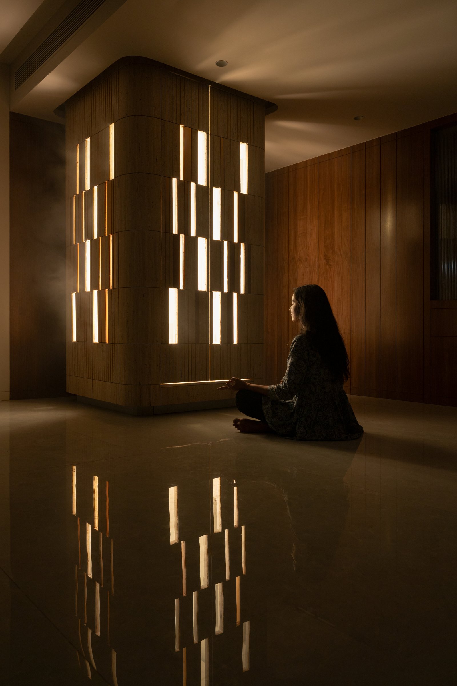 After dark, the temple does what it was designed to do, emitting a soft glow through its calibrated travertine slots