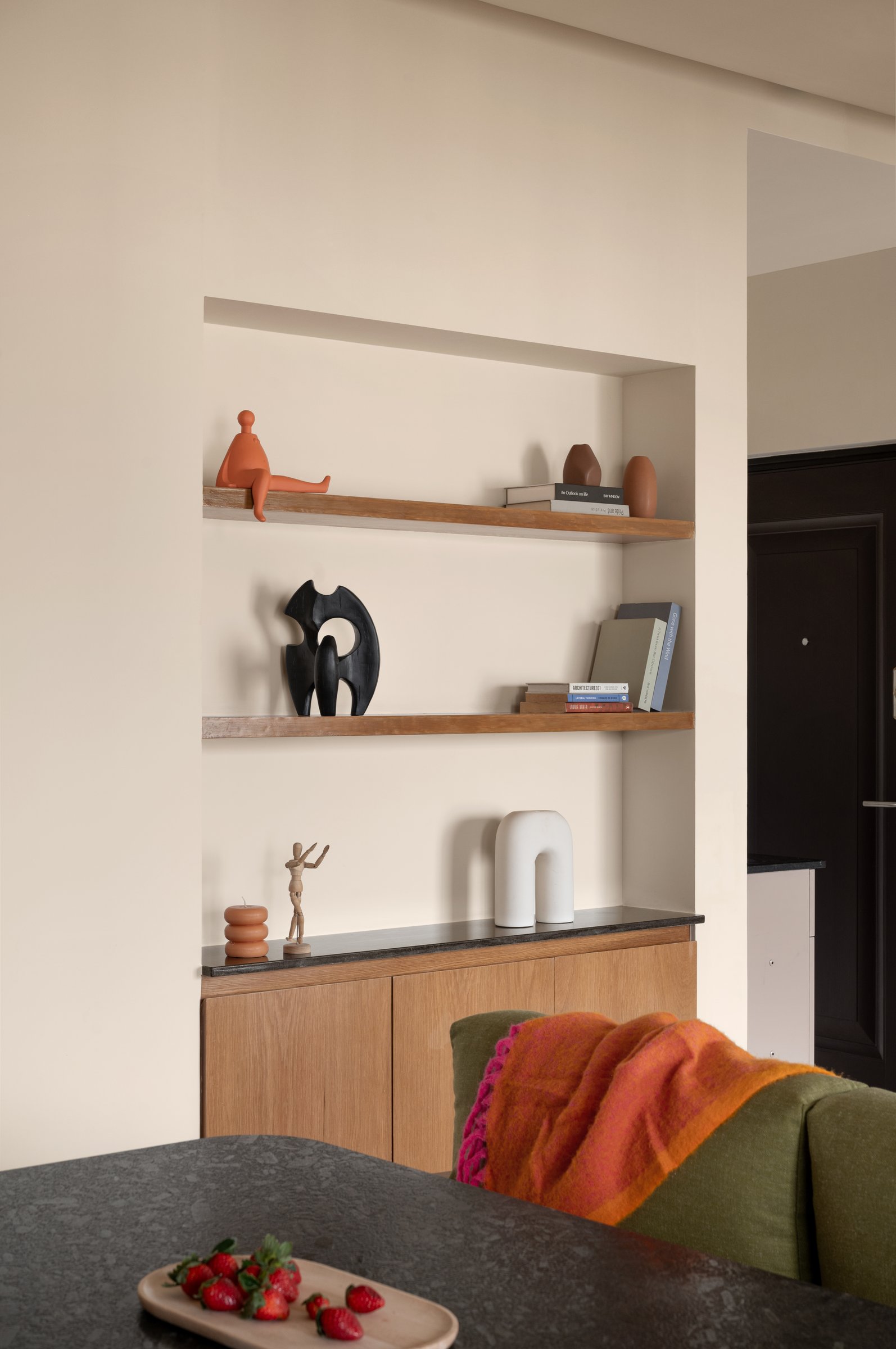 A recessed alcove on the dining wall: few objects, carefully chosen, holding the home's most concentrated piece of curation