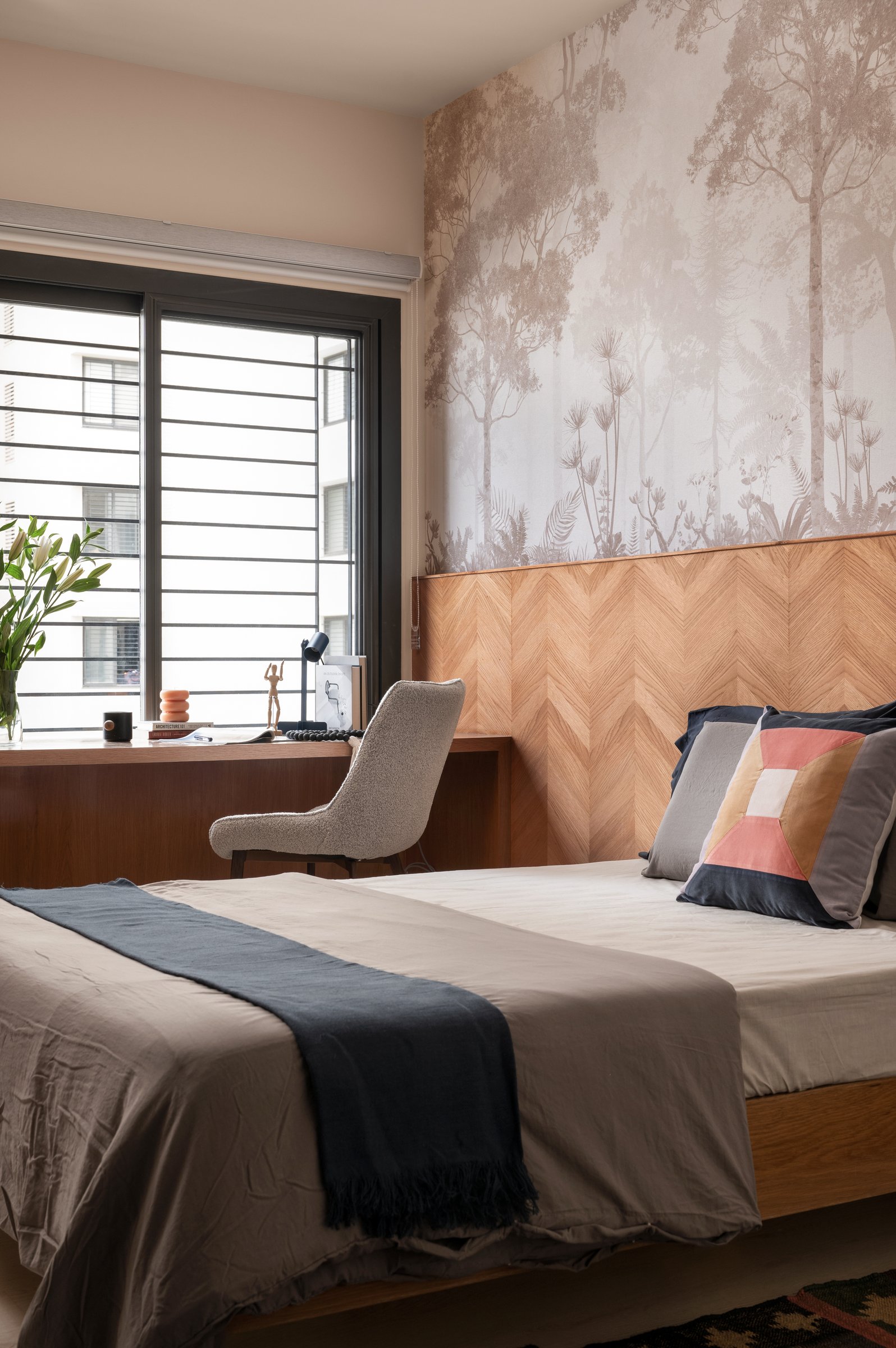 The guest bedroom: a chevron-panel headboard and a sepia forest wallpaper bring craft to a room that might otherwise have read as plain
