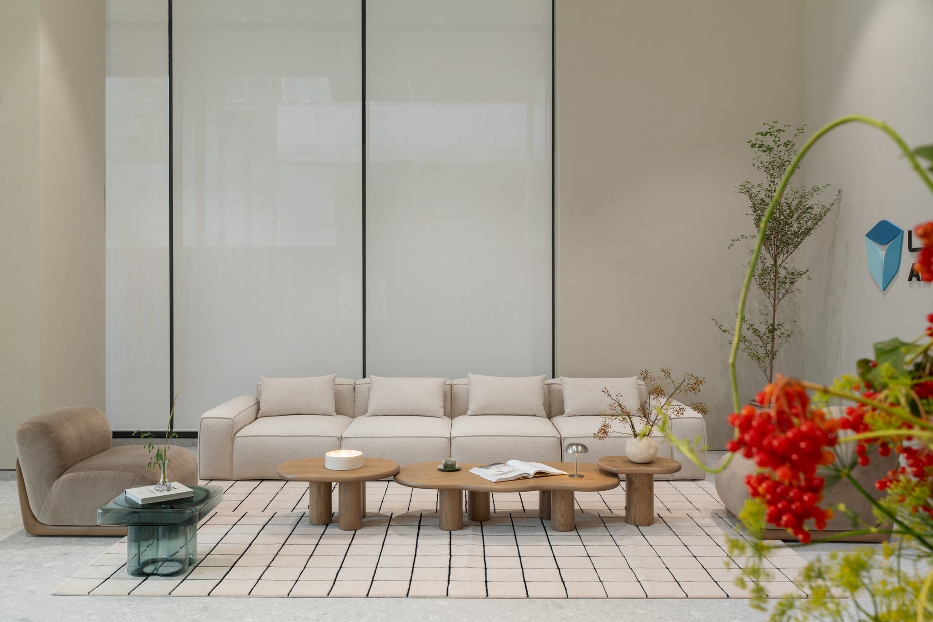 The ground-floor lounge, where a modular oatmeal sofa and a constellation of organic-shaped wooden tables set the project's quiet material grammar