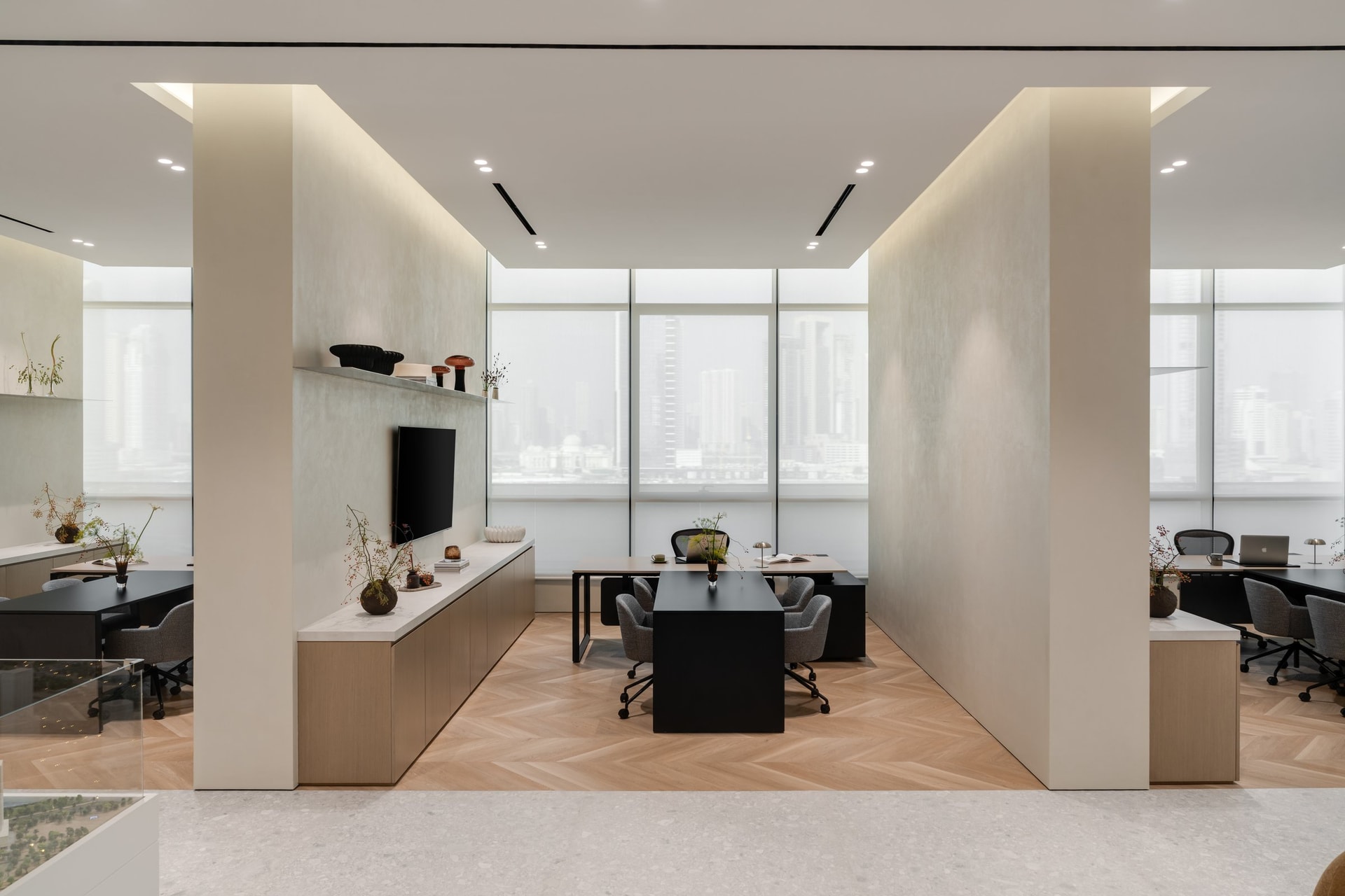 A private office volume, framed by pale oak credenzas and a city view treated as material rather than spectacle
