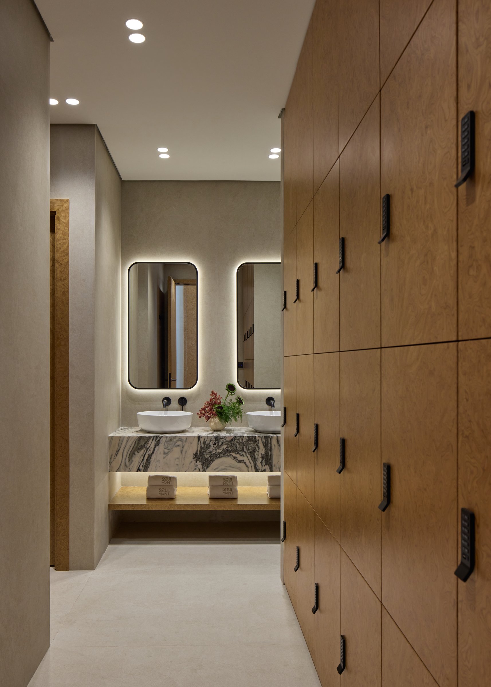 The changing room: a full wall of burl wood lockers leading to the vanity beyond