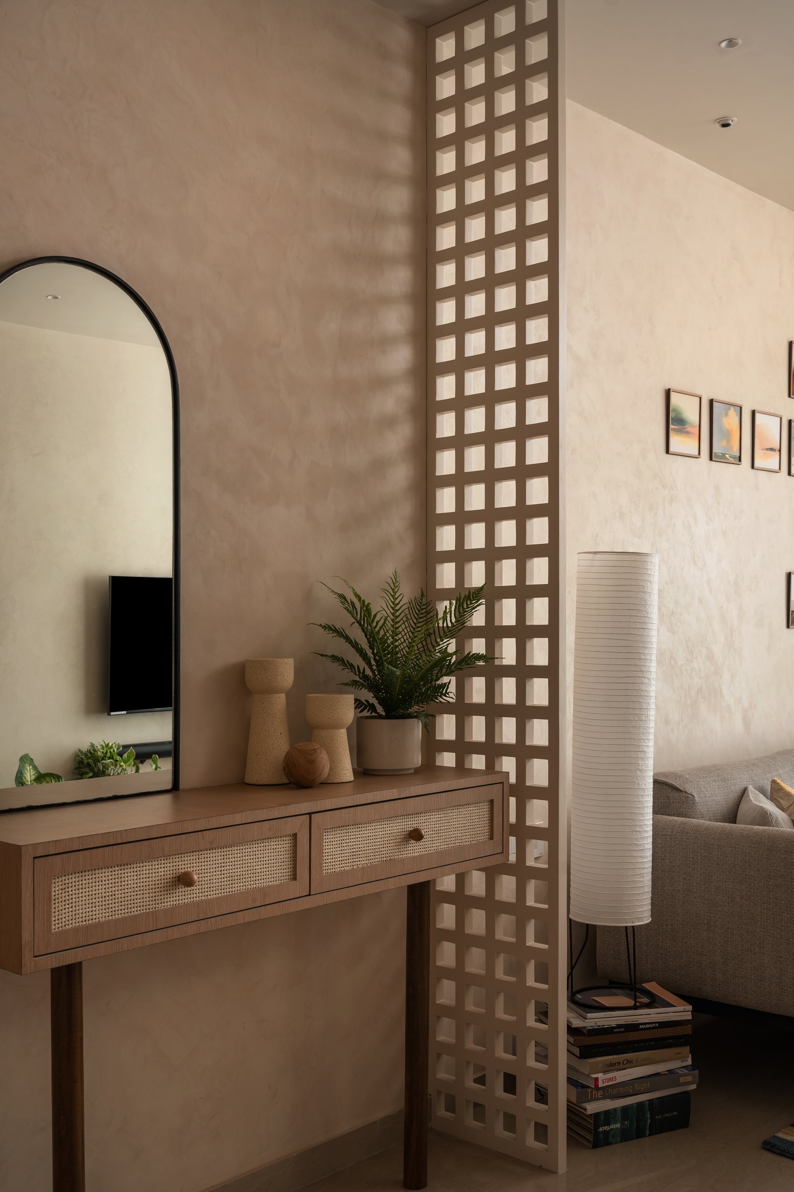 The wood lattice screen, read up close: divider, window and light fixture in a single gesture