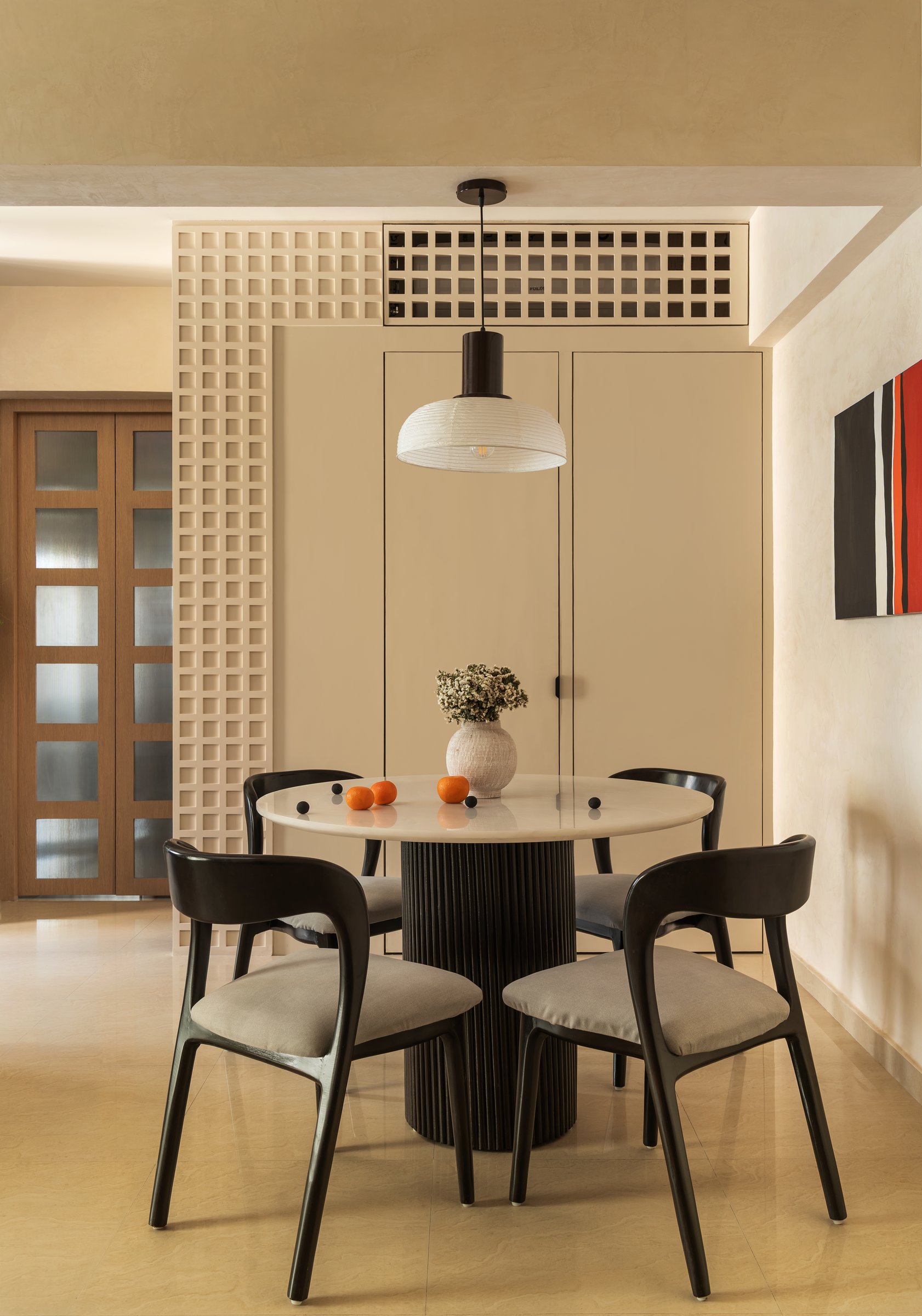 The dining nook: a fluted cylindrical base, four sculptural chairs and a deep grid screen recast as architectural cladding