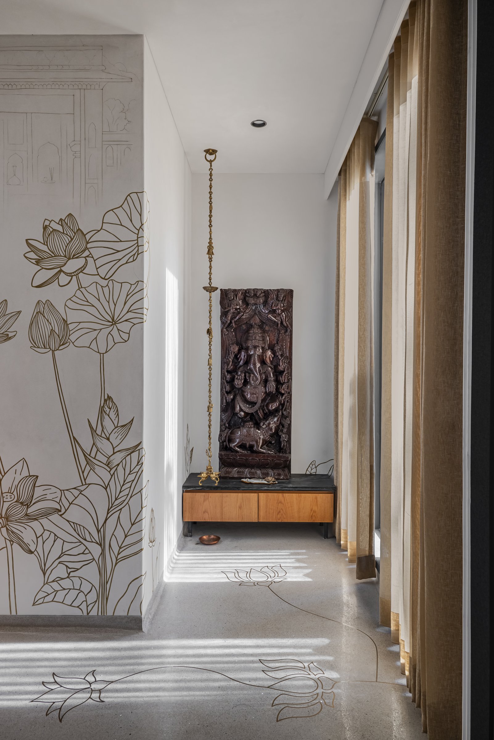 The pooja niche, with its carved Ganesh panel and inlaid lotus floor