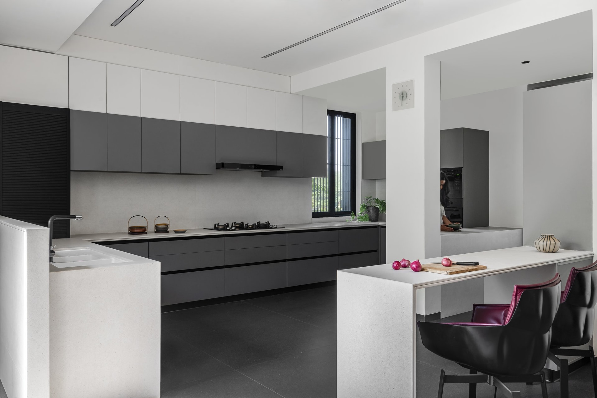 The kitchen earns its restraint, two-toned cabinetry and a stone breakfast counter doing the work