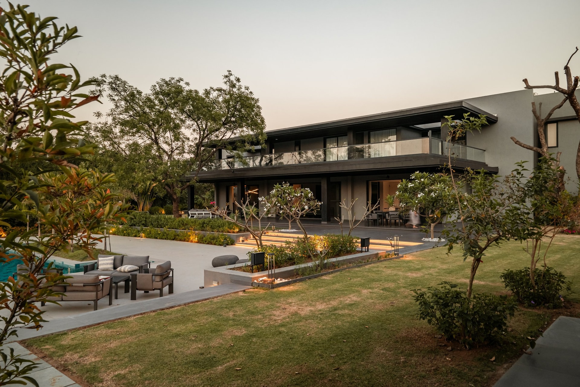 The rear elevation at dusk: a long horizontal volume sitting low on the land