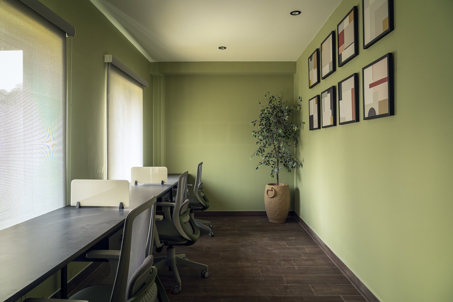 The business centre, in sage green with a long shared worktable and pale roller blinds