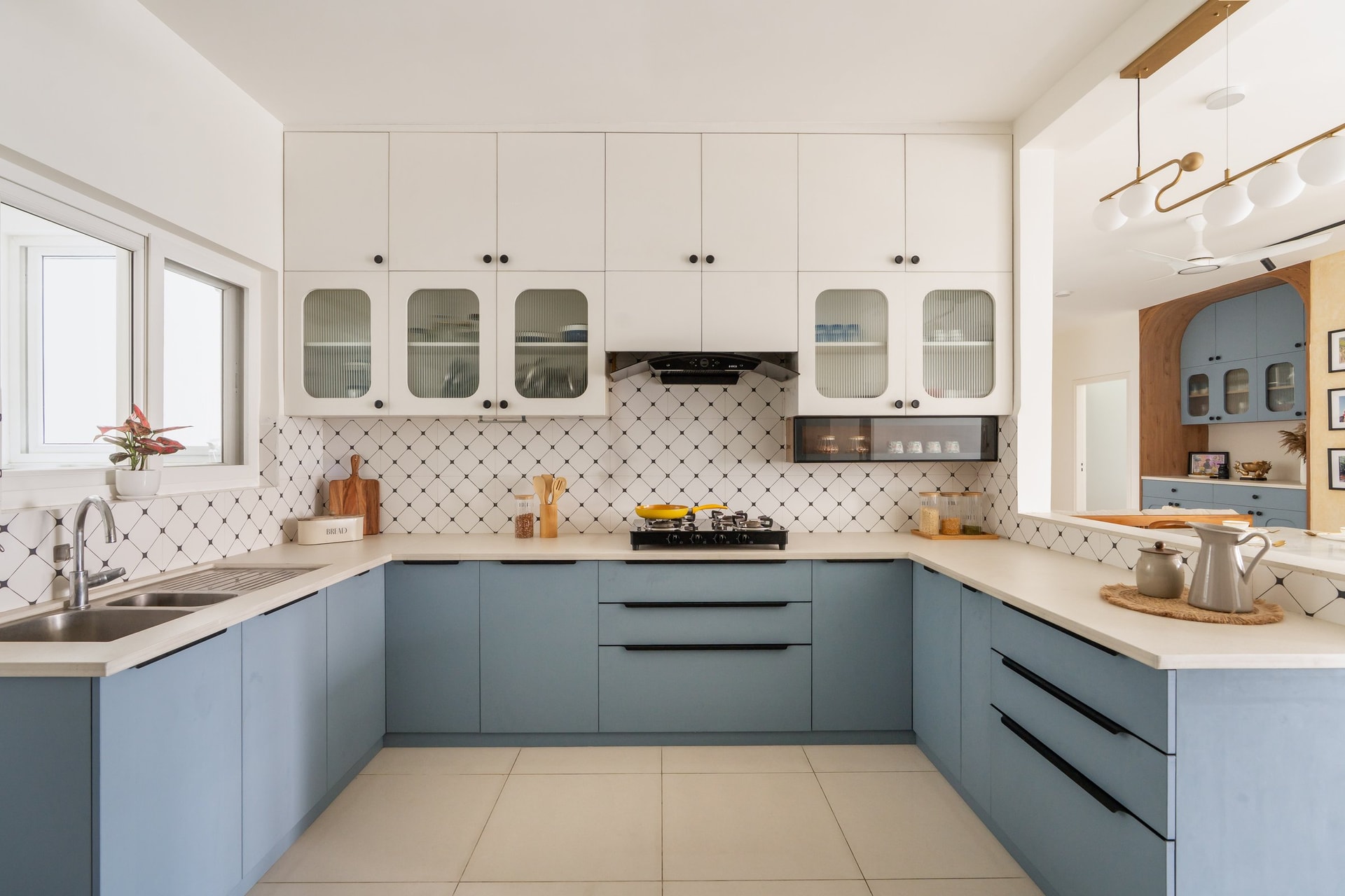 The kitchen in powder-blue cabinetry, with a diamond-patterned backsplash adding rhythm to the U-shaped layout