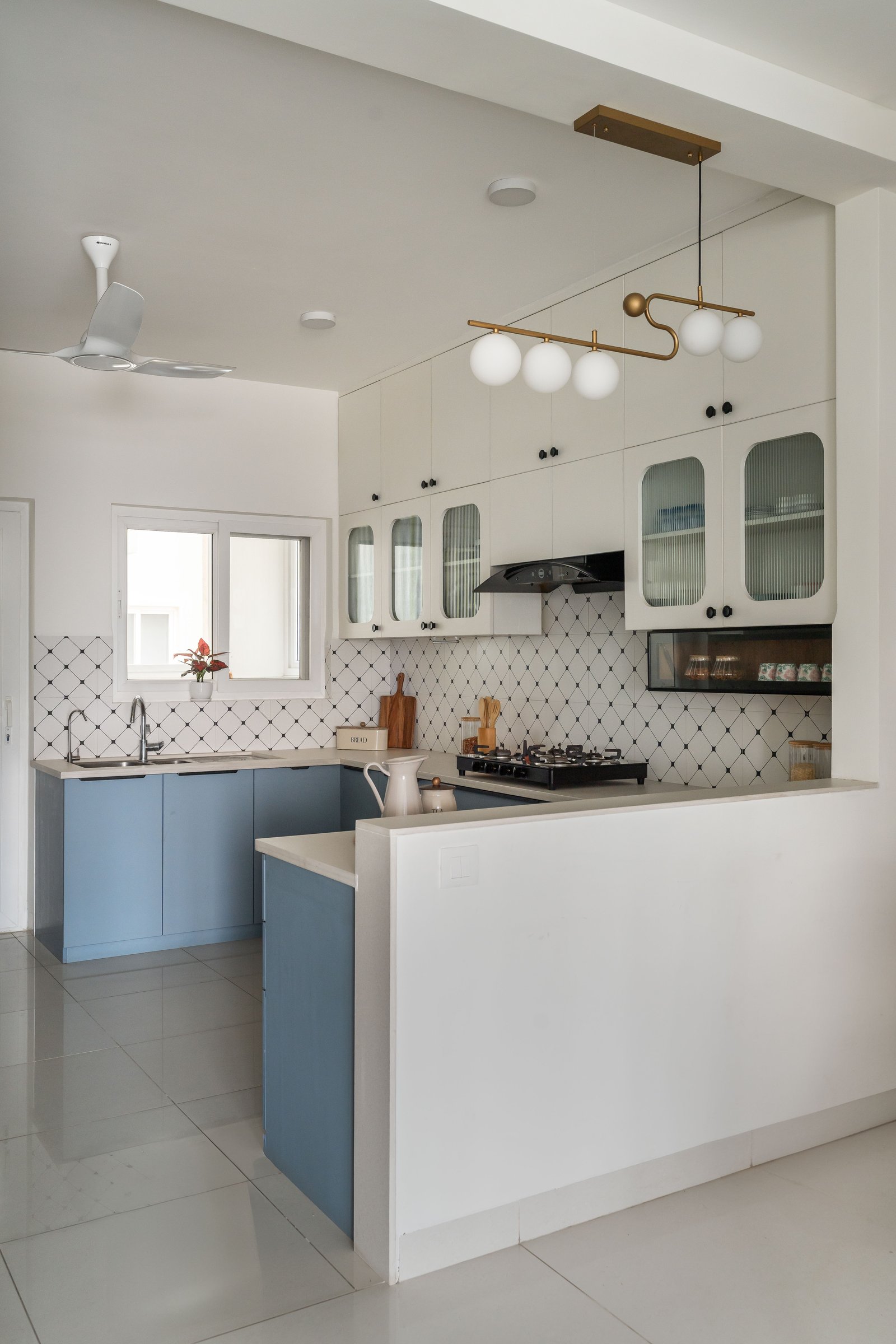 From another angle, the brass-and-globe pendant becomes the kitchen's single sculptural extravagance