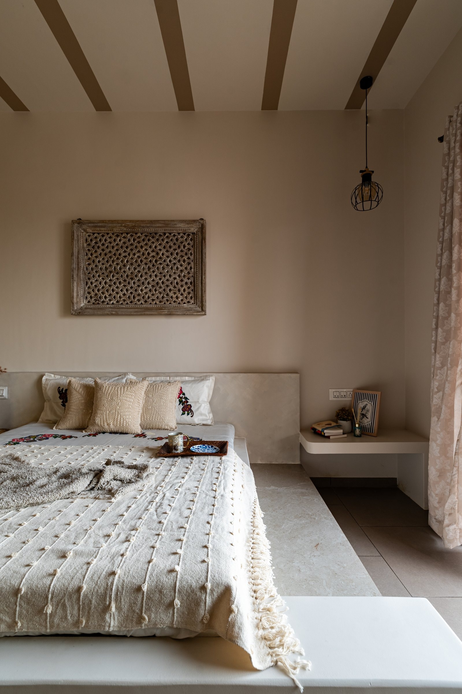 The full bedroom view, painted ceiling bands giving the room a subtle directional rhythm