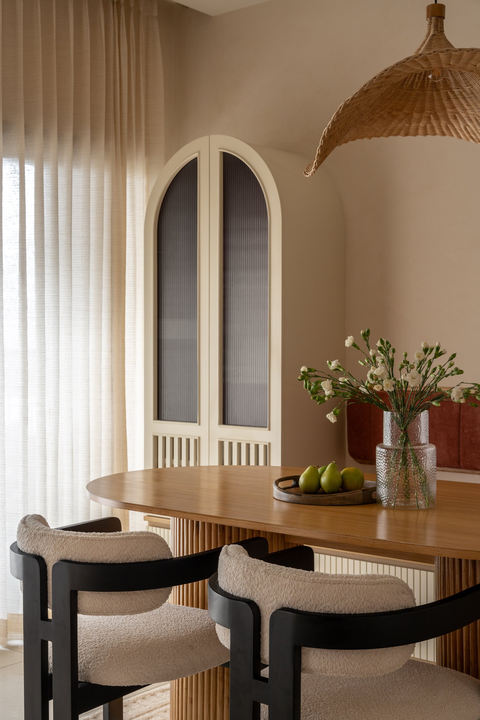 An arched reeded-glass cabinet reads more as architecture than as joinery