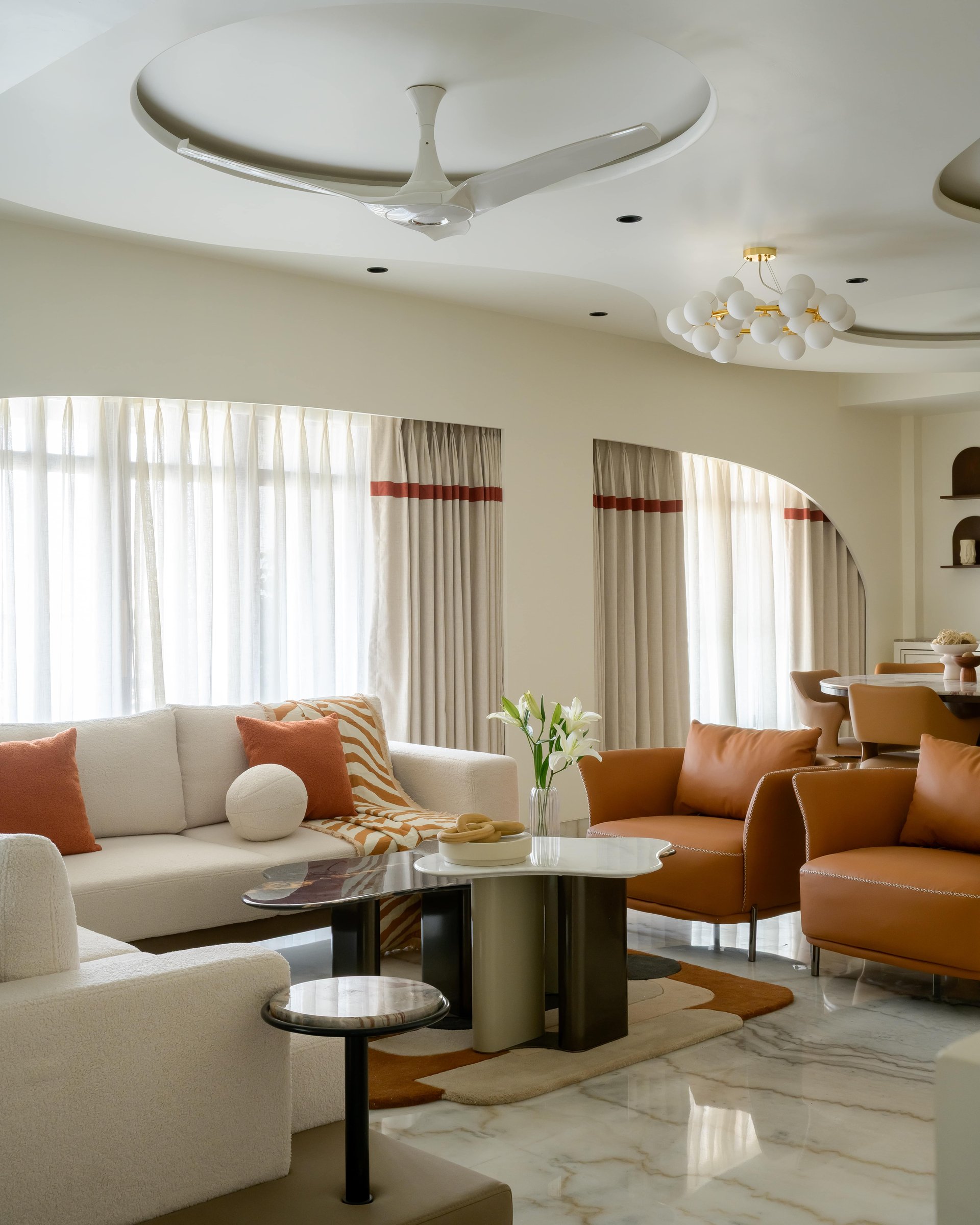 The seating arrangement: tan leather armchairs and a boucle sofa held in deliberate contrast
