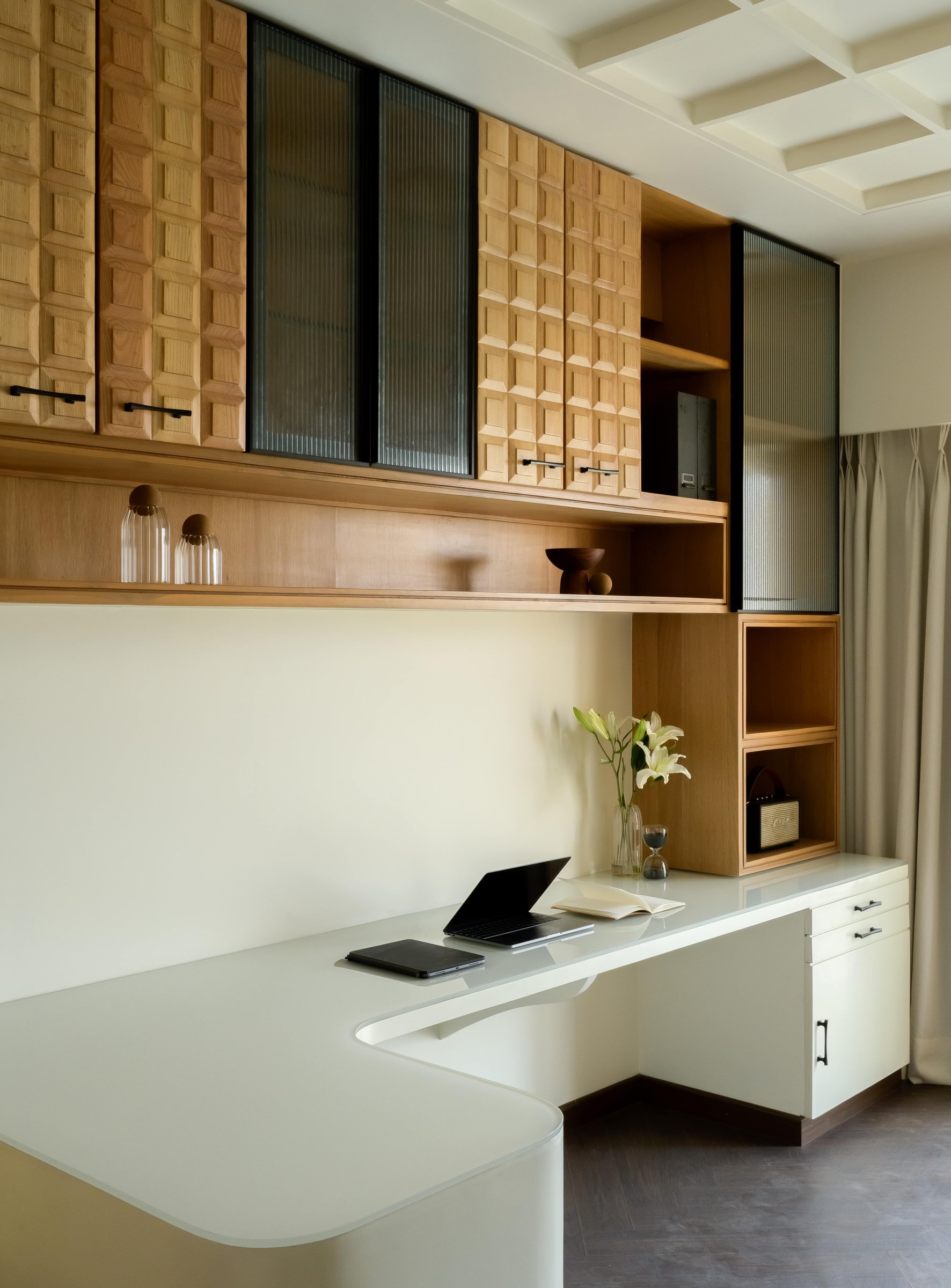 The desk arrangement, where fluted glass alternates with the patterned wood fronts