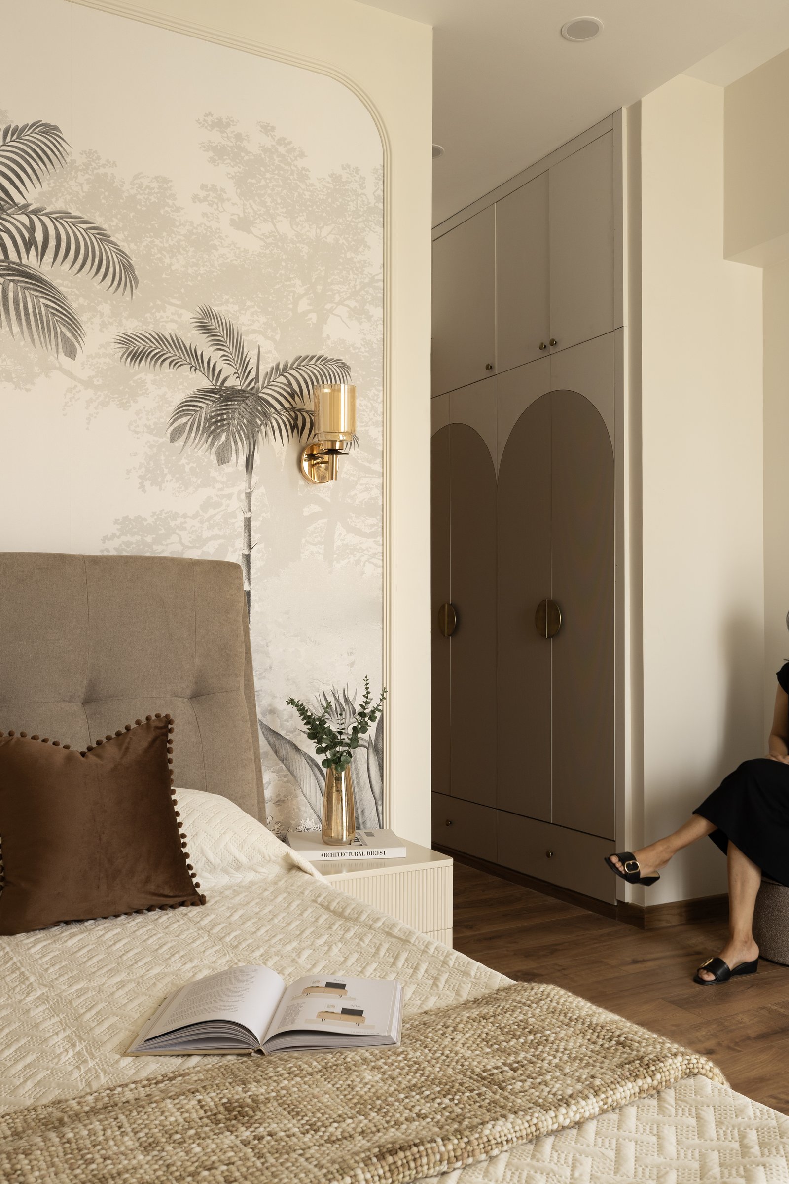 The arch repeats from headboard to wallpaper niche to wardrobe inlay, establishing the home's underlying rhythm