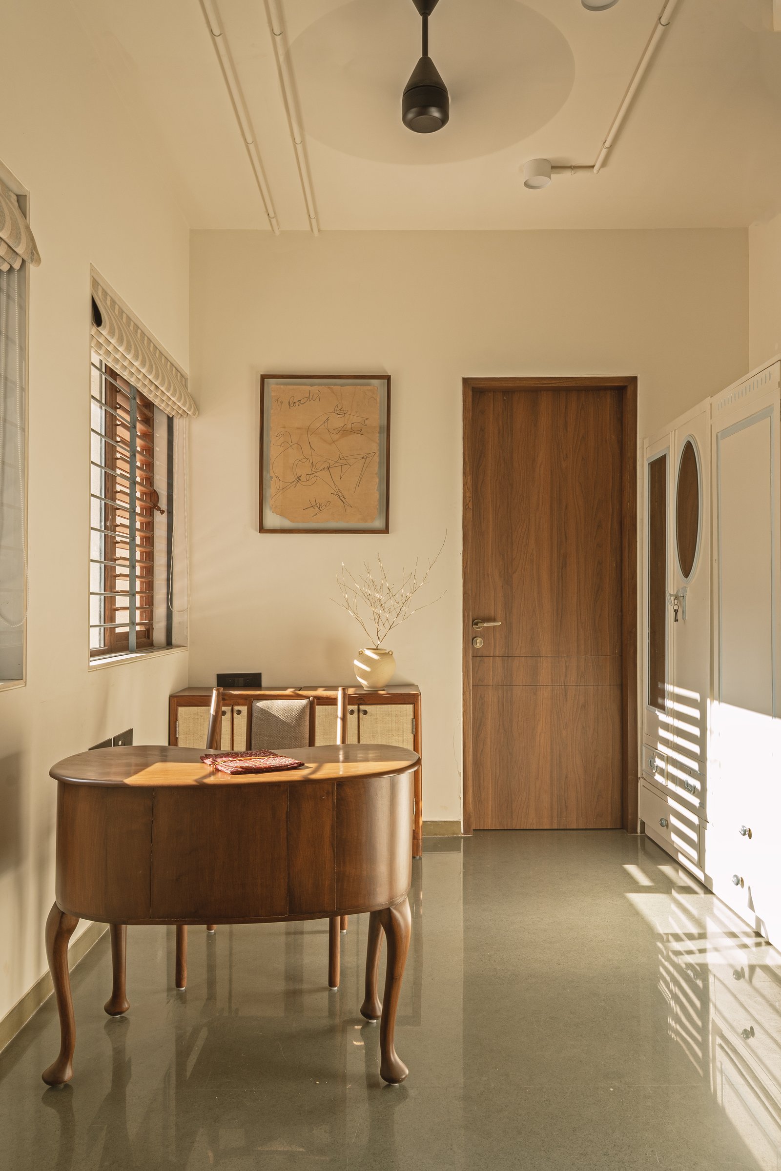A sculptural desk on cabriole legs anchors the study room, the polished green floor stitching it back to the rest of the home