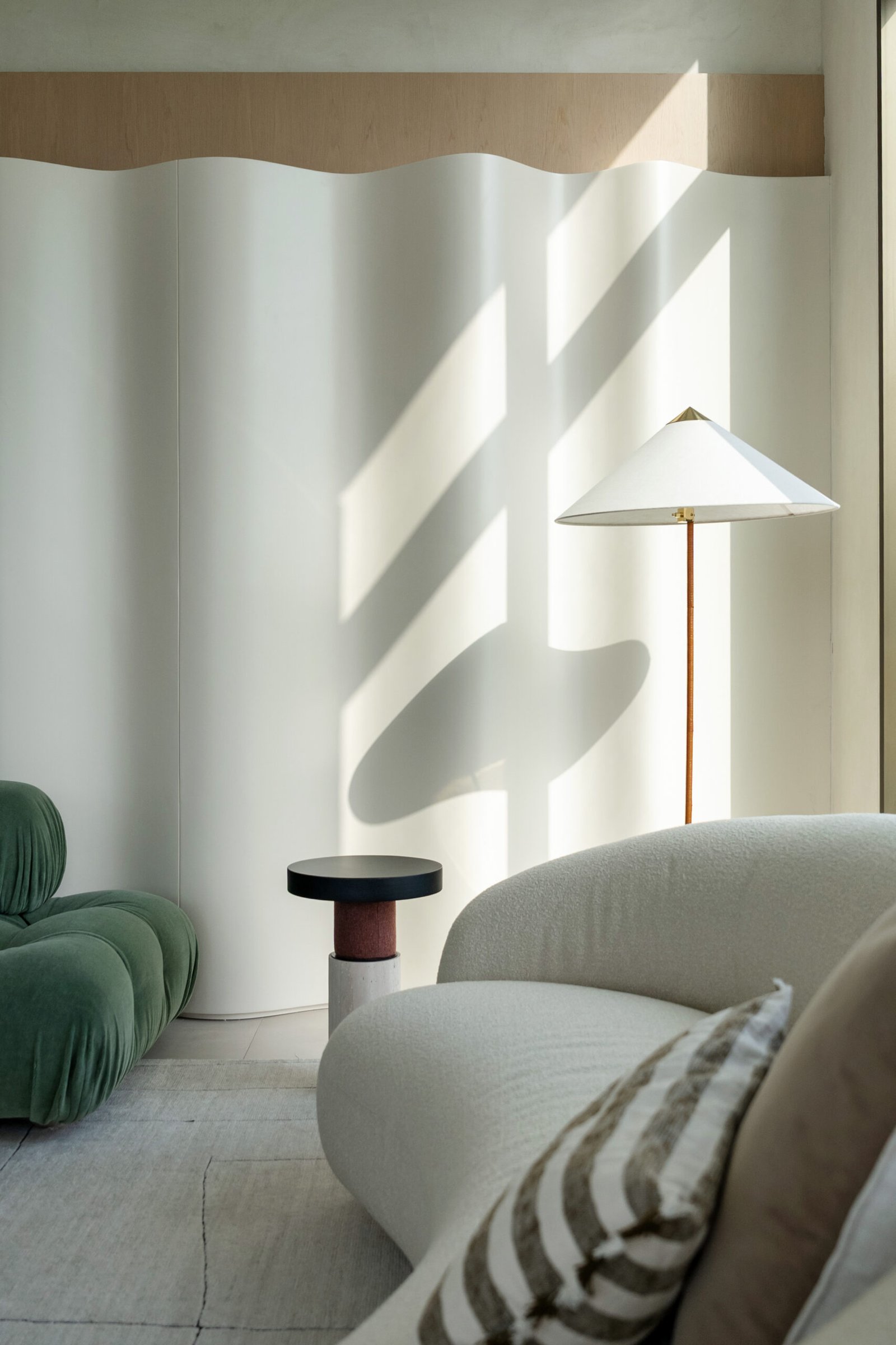 A quieter corner of the living room, where curved plaster registers light as a material in its own right