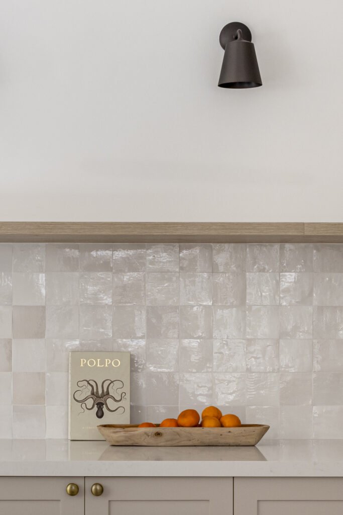 A closer view of the zellige backsplash, the project's quiet hero, sharpened by a single black wall sconce