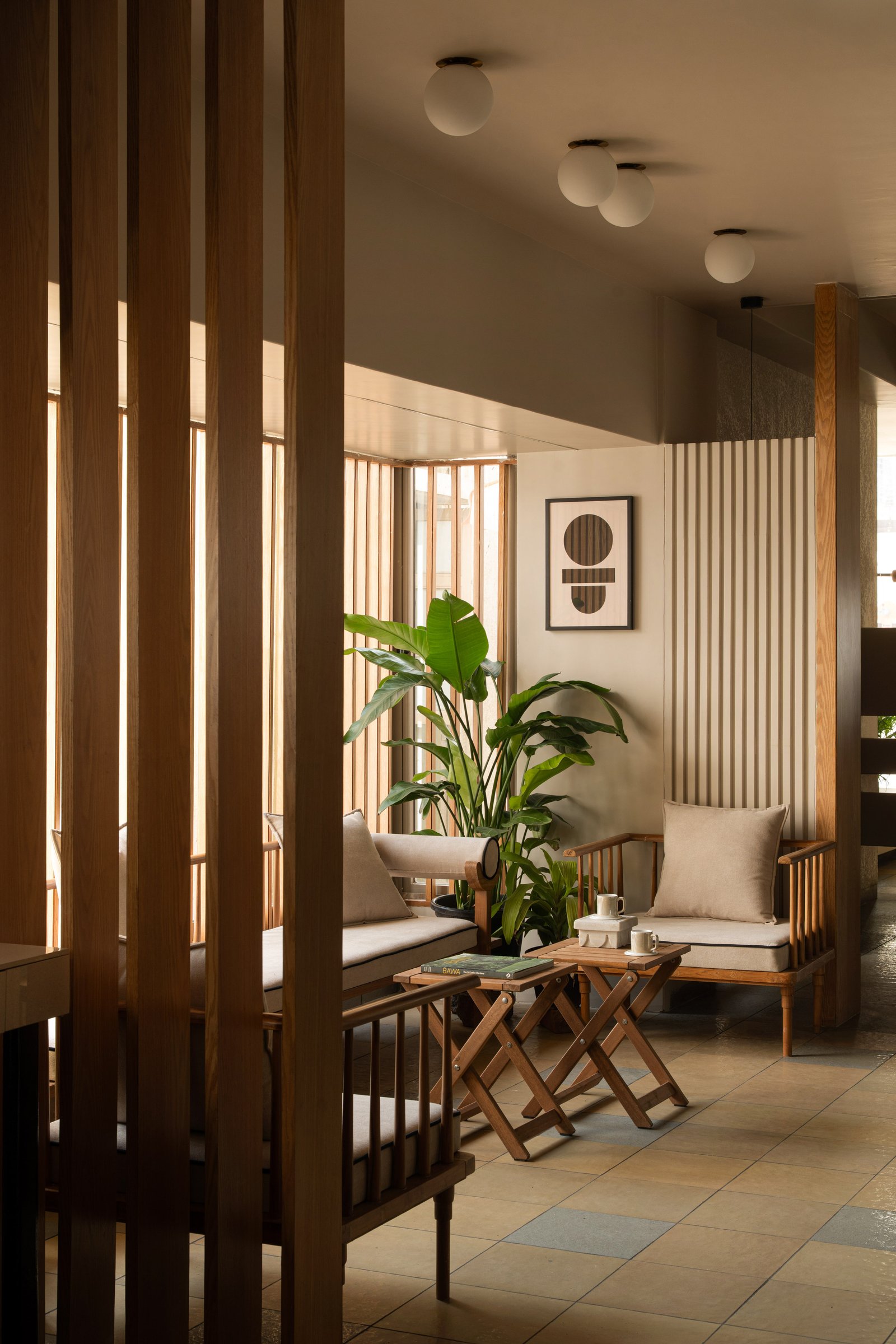 The reception lounge, where cane-and-wood settees and vertical wood fins set the building's interior register