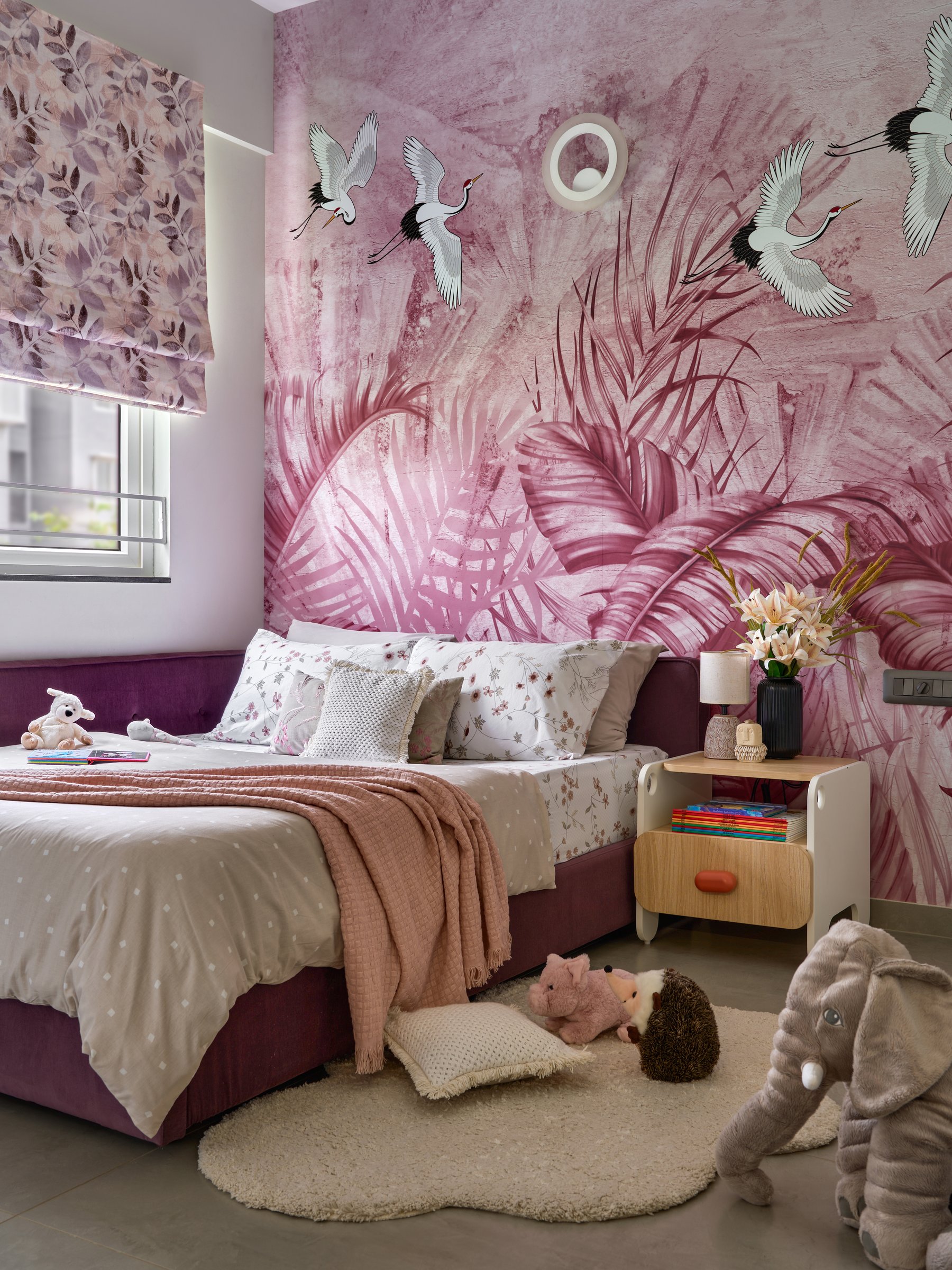 The children's room, wrapped in a mauve mural of palms and cranes, with a custom low-lying bed designed for a toddler