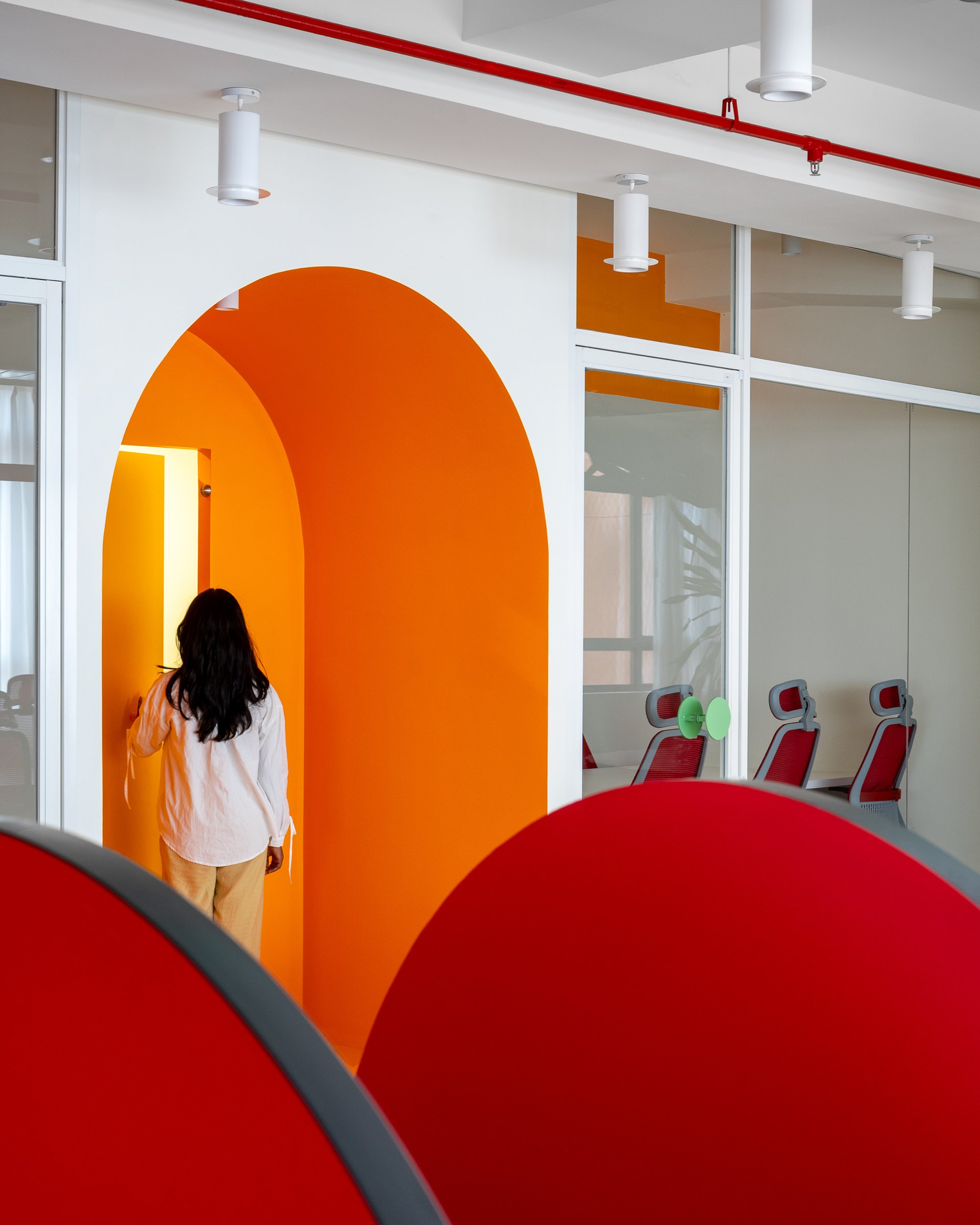 The arched orange portal, where pigment does the work of signage and transitions between zones