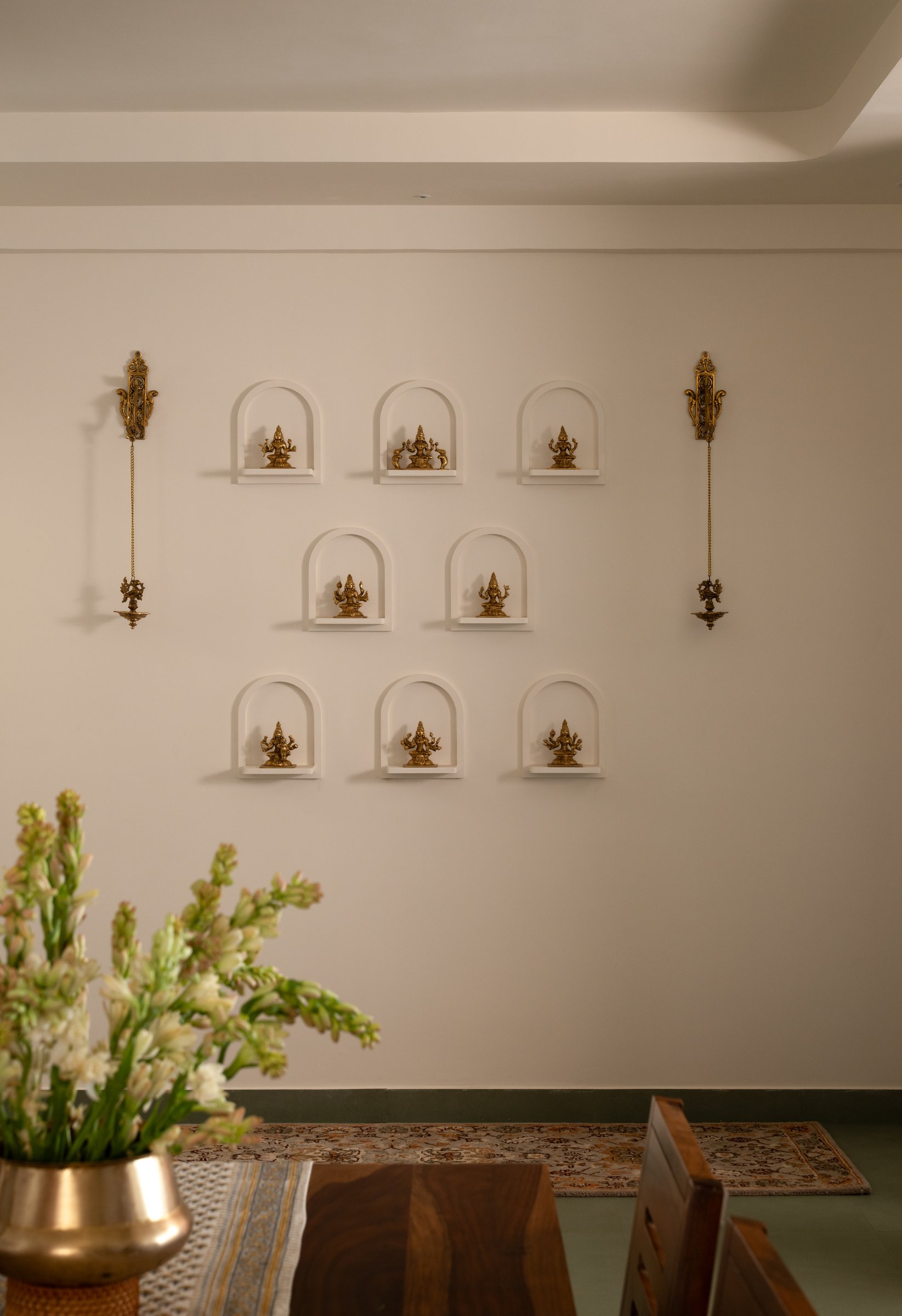 The wall of arched plaster niches in the dining area, the sacred distributed into the everyday act of eating