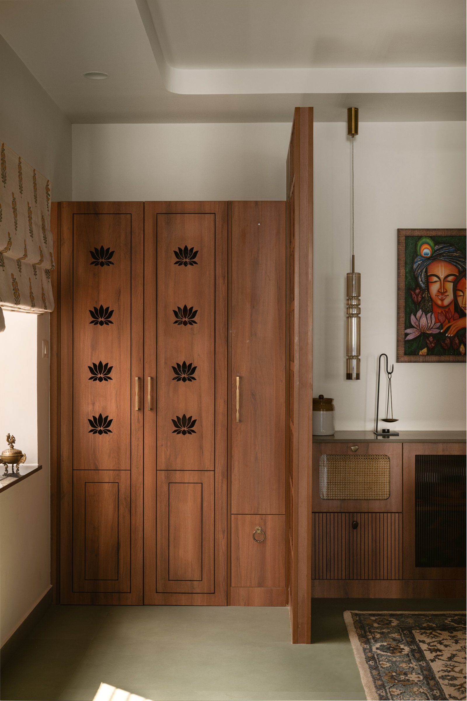 The same cabinet closed: lotus-motif inlay on the doors lets the shrine read as part of the wall when needed