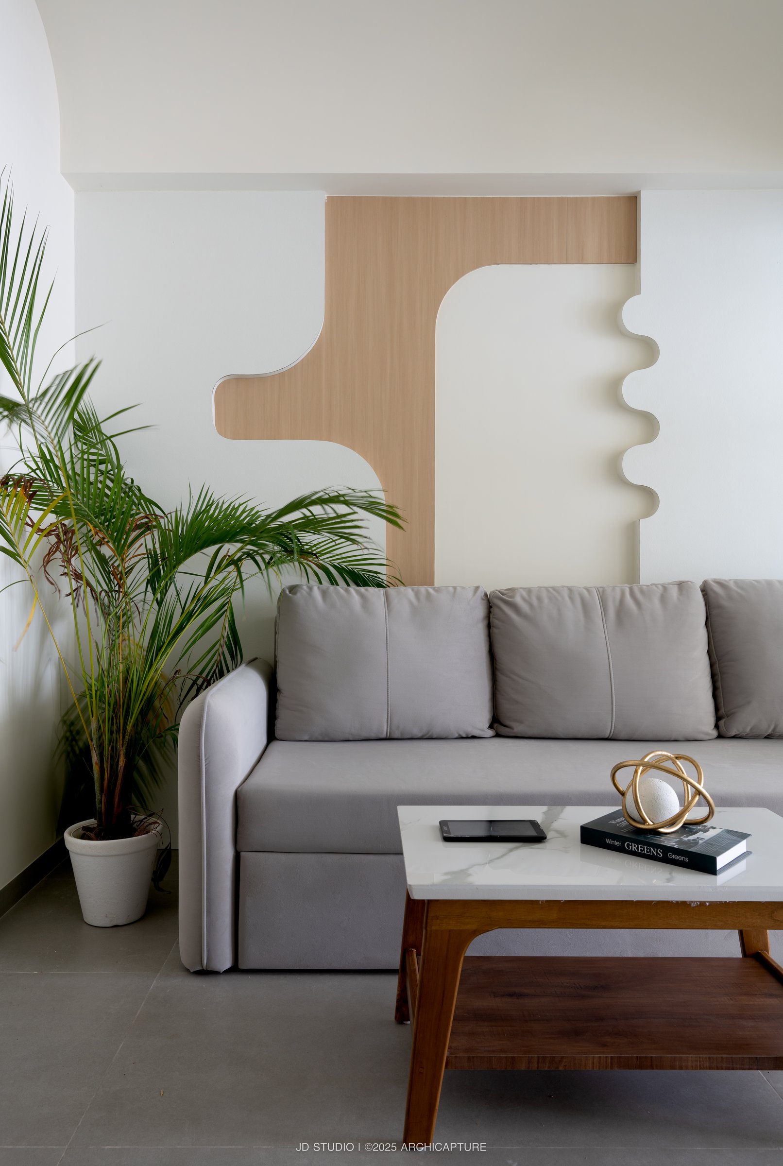 The lounge wall, where a wood-and-plaster composition does the work that furniture often has to