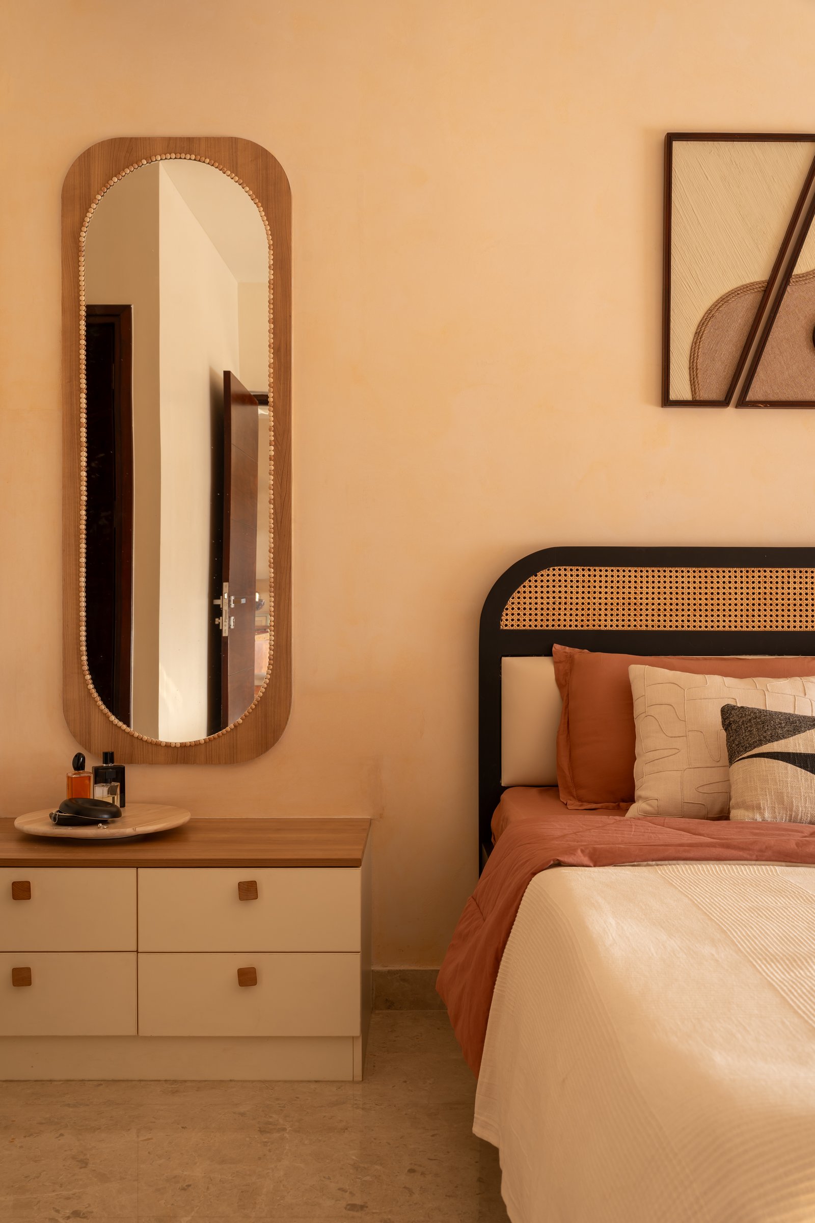 The parents' bedroom, where a cane-and-black headboard echoes the dining chairs in a different register