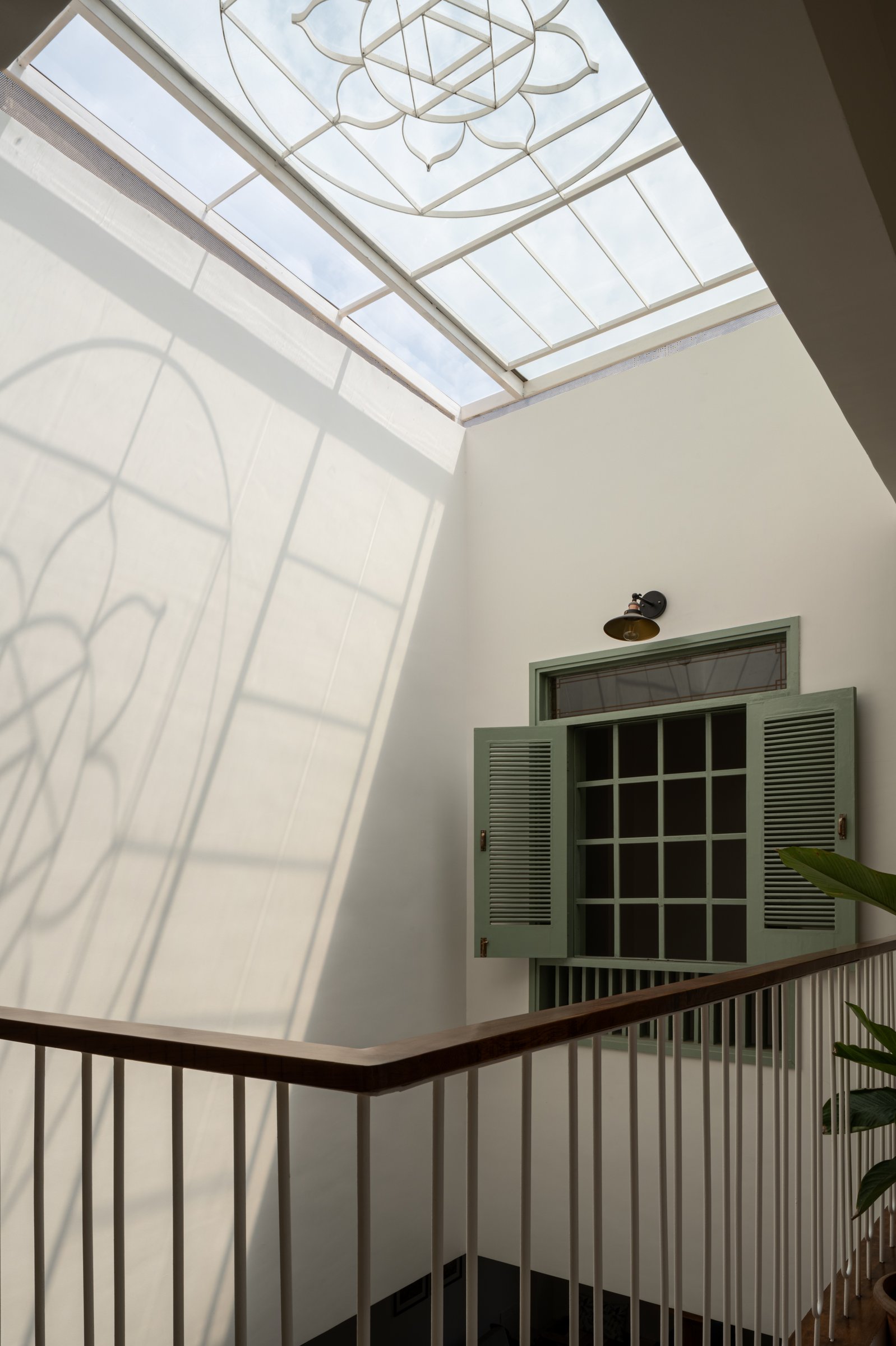 The first-floor landing, where a louvred internal window opens onto the central void, a contemporary reading of the wada's internal verandah
