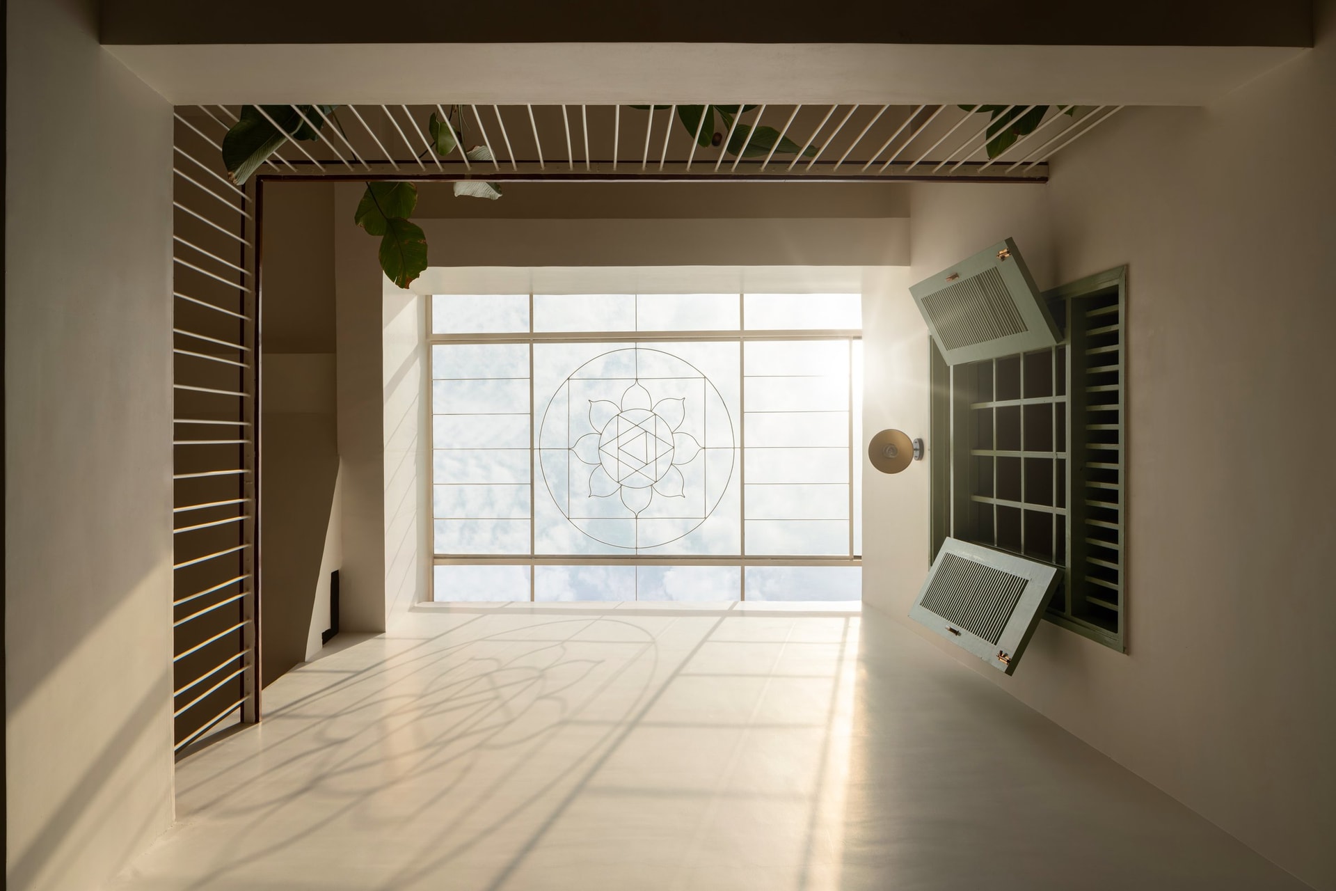 The skylight from the upper landing: a lotus-and-yantra motif worked into the metalwork projects a slow-moving drawing of light through the day