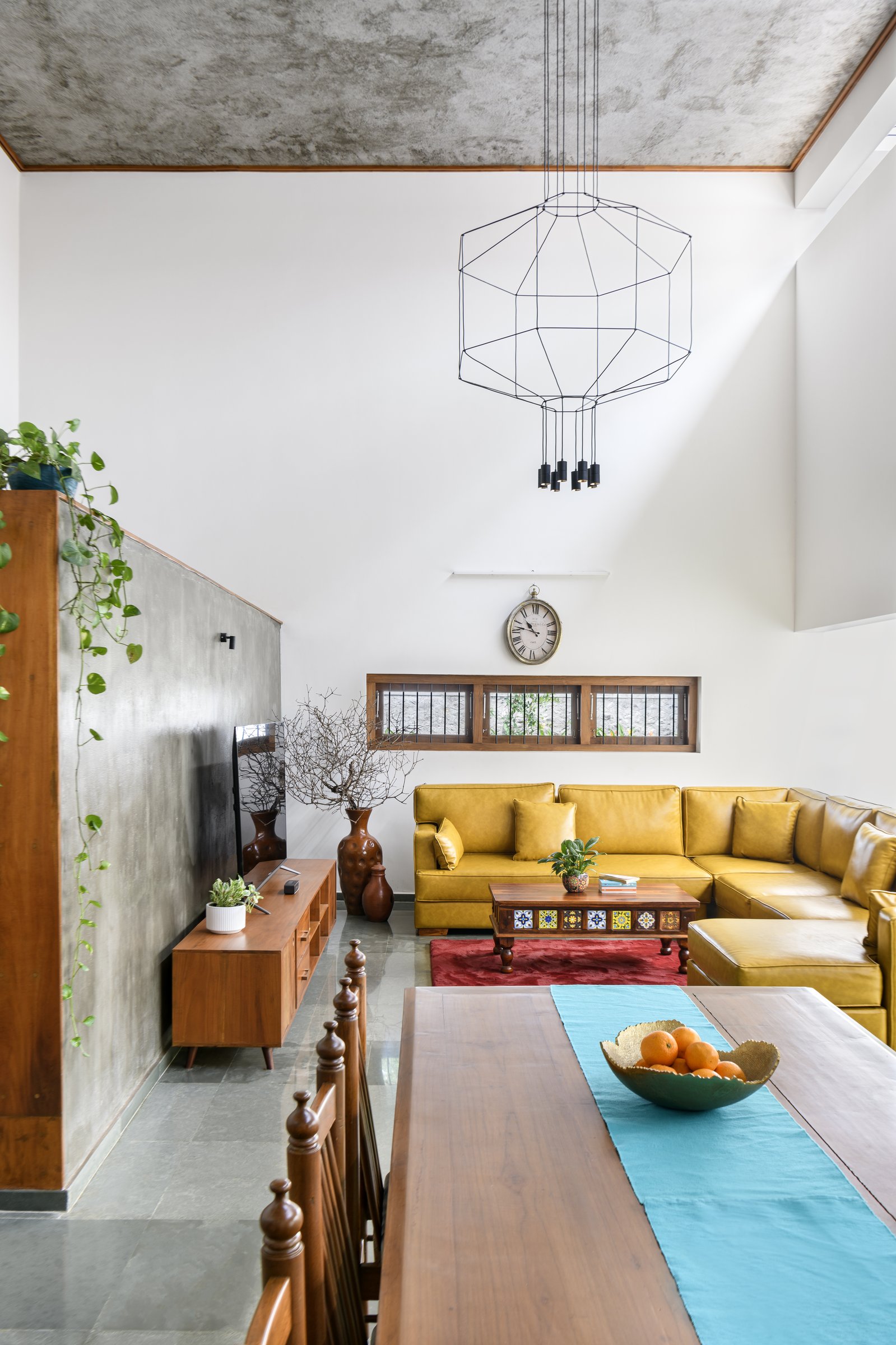 A closer view of the same room, where the mustard sectional and patterned-tile coffee table carry the warmth