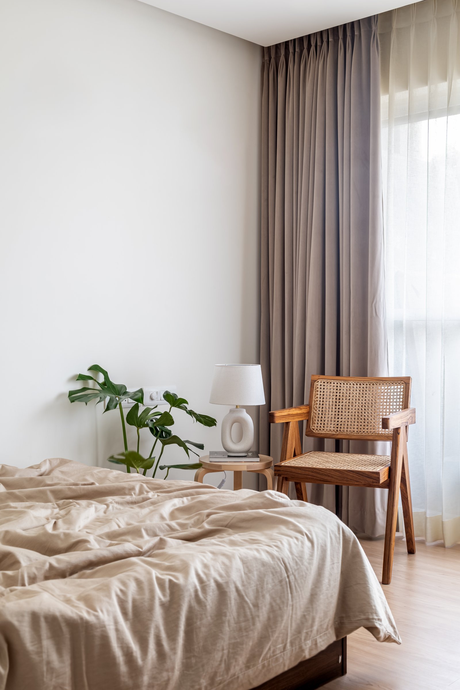 The second bedroom takes a restrained tone, with a single Chandigarh-style chair and linen in oatmeal