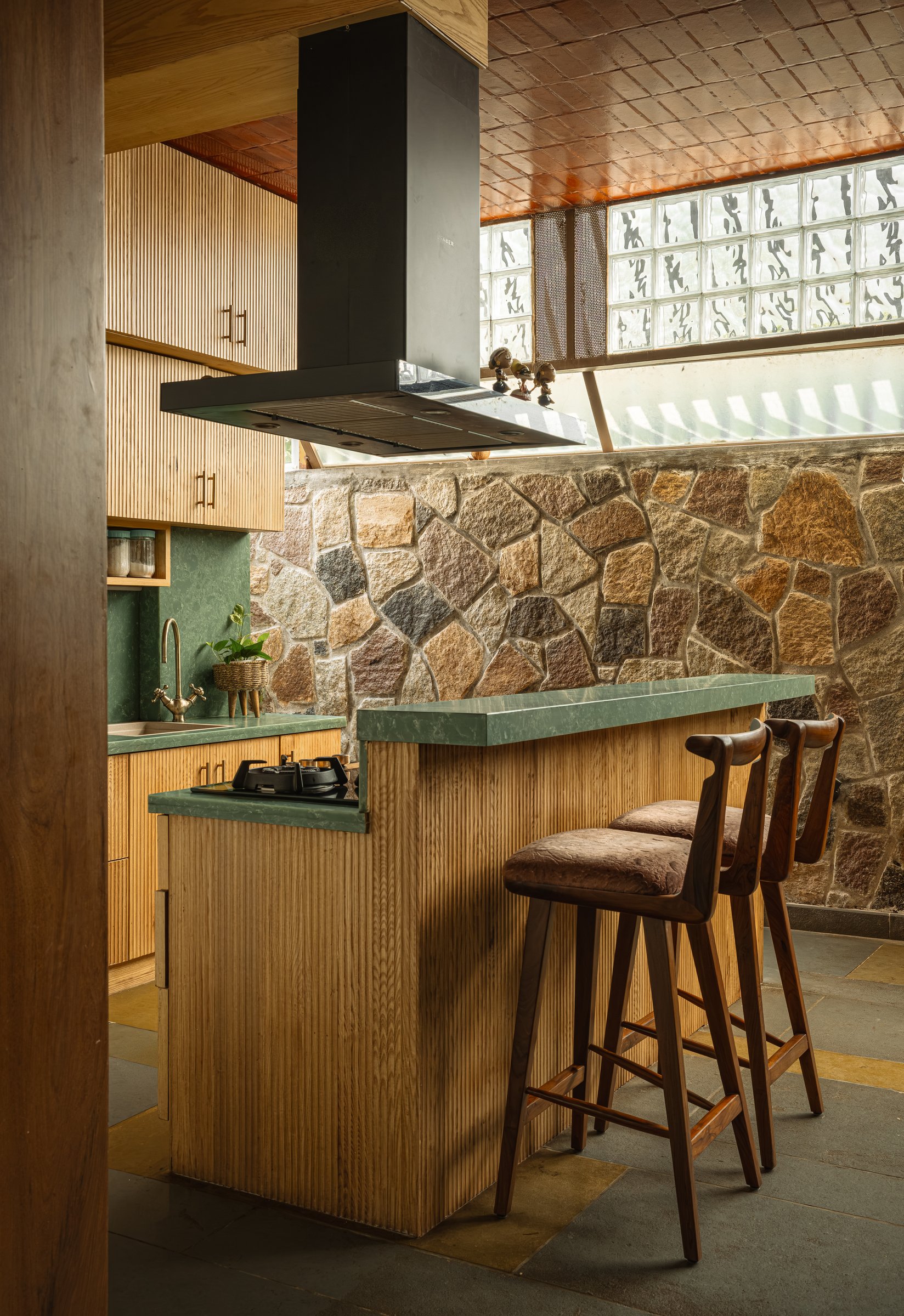 The kitchen's working side, with fluted hardwood cabinetry and a compact island that lets two people cook in a small footprint
